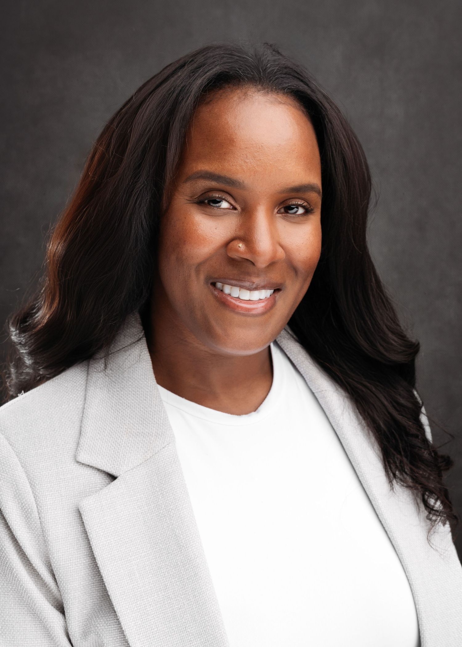 Professional headshots featuring a person in a white blazer against a gray backdrop.