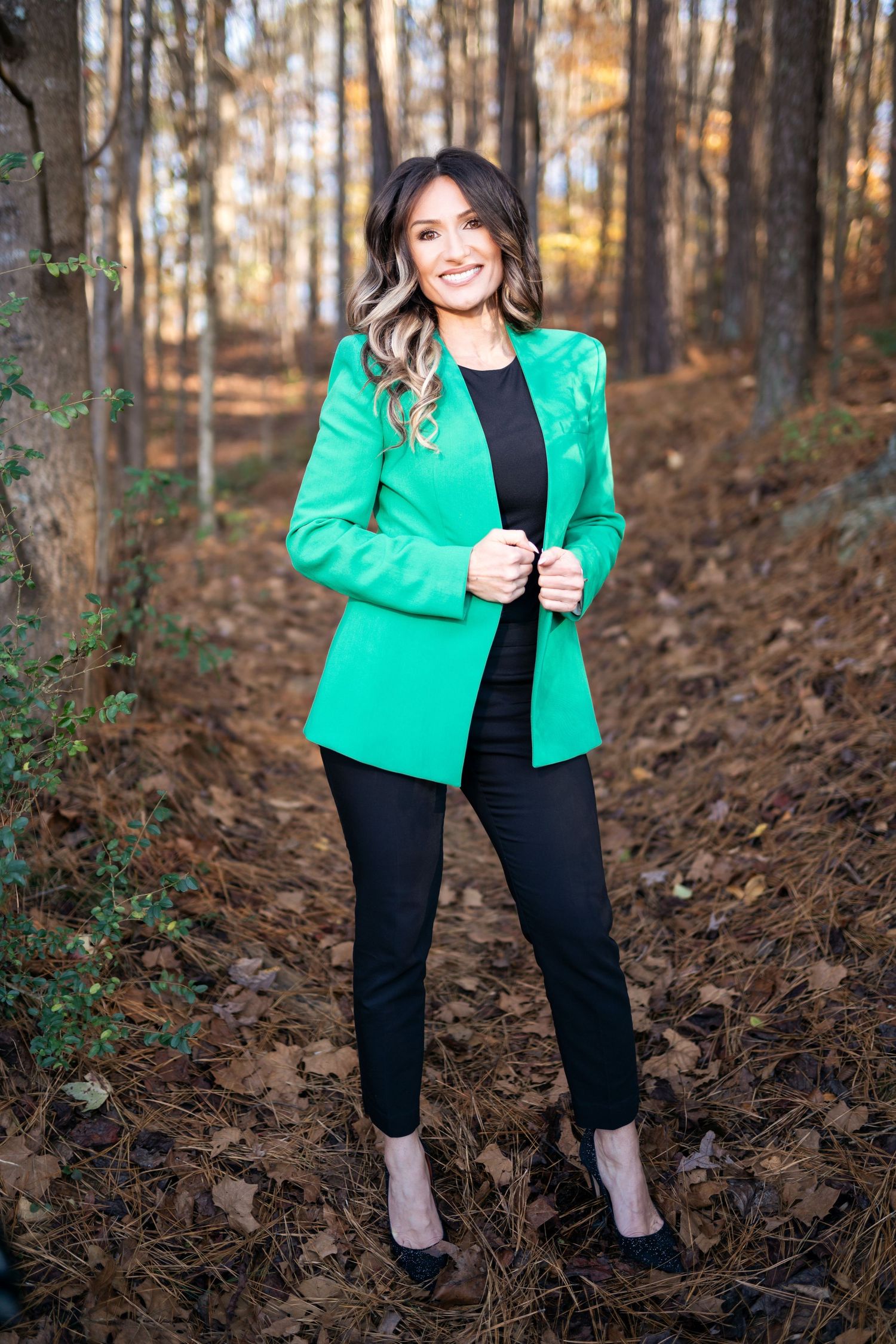 Outdoor photos of a person wearing a bright green blazer and black pants in a wooded setting.