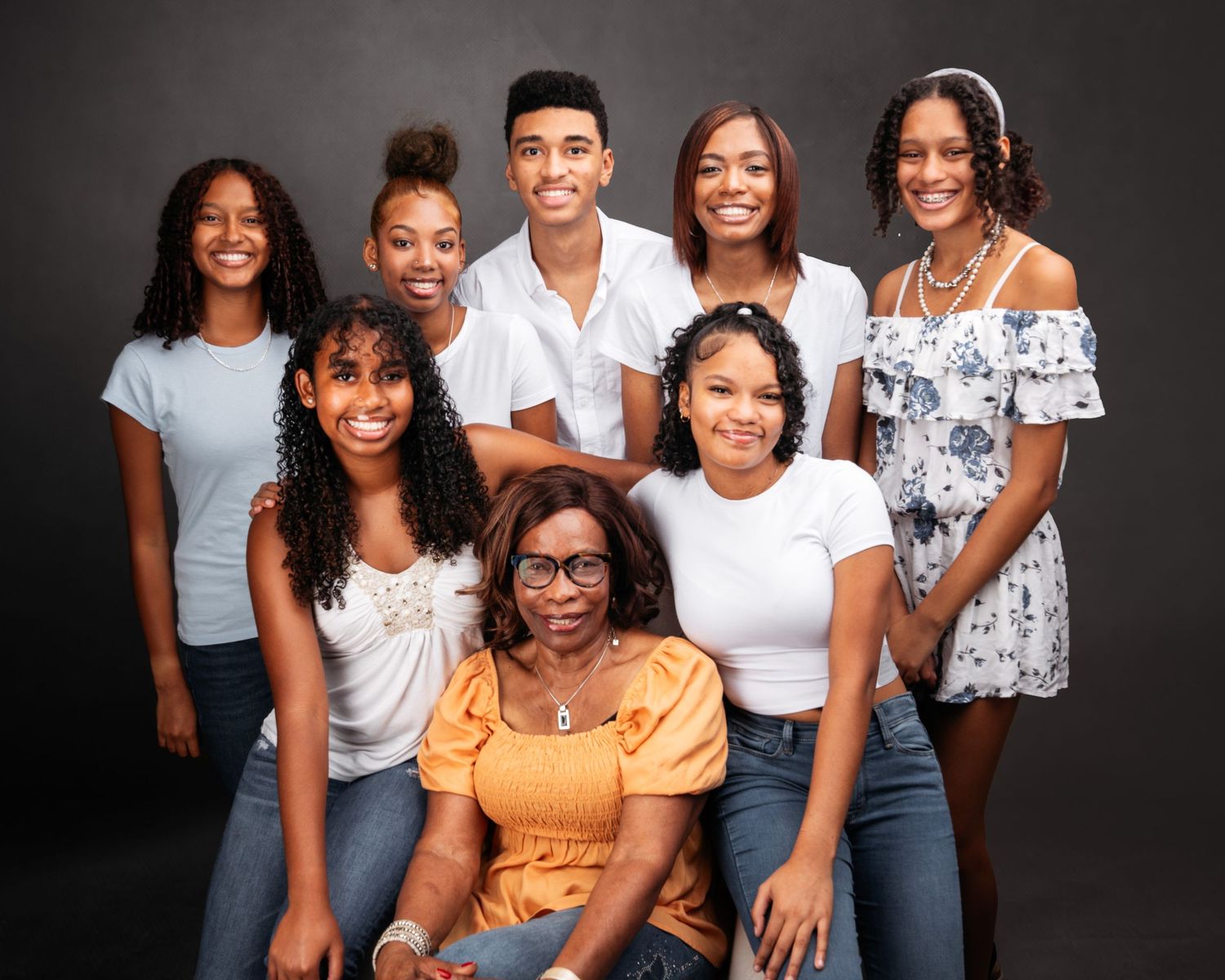 Family portrait session with group wearing coordinated white and blue outfits.