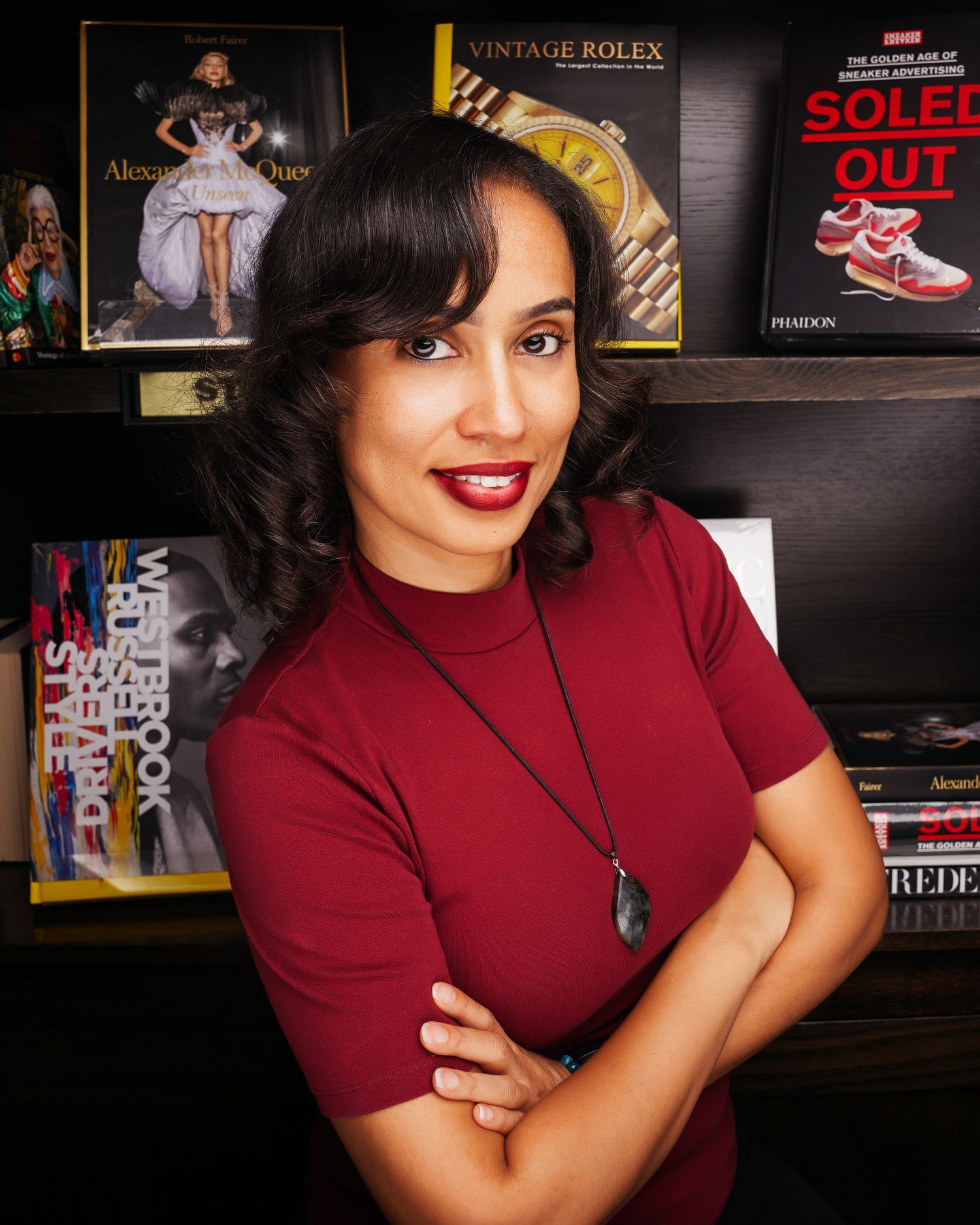 Portrait series in burgundy top against dark background with vintage posters.