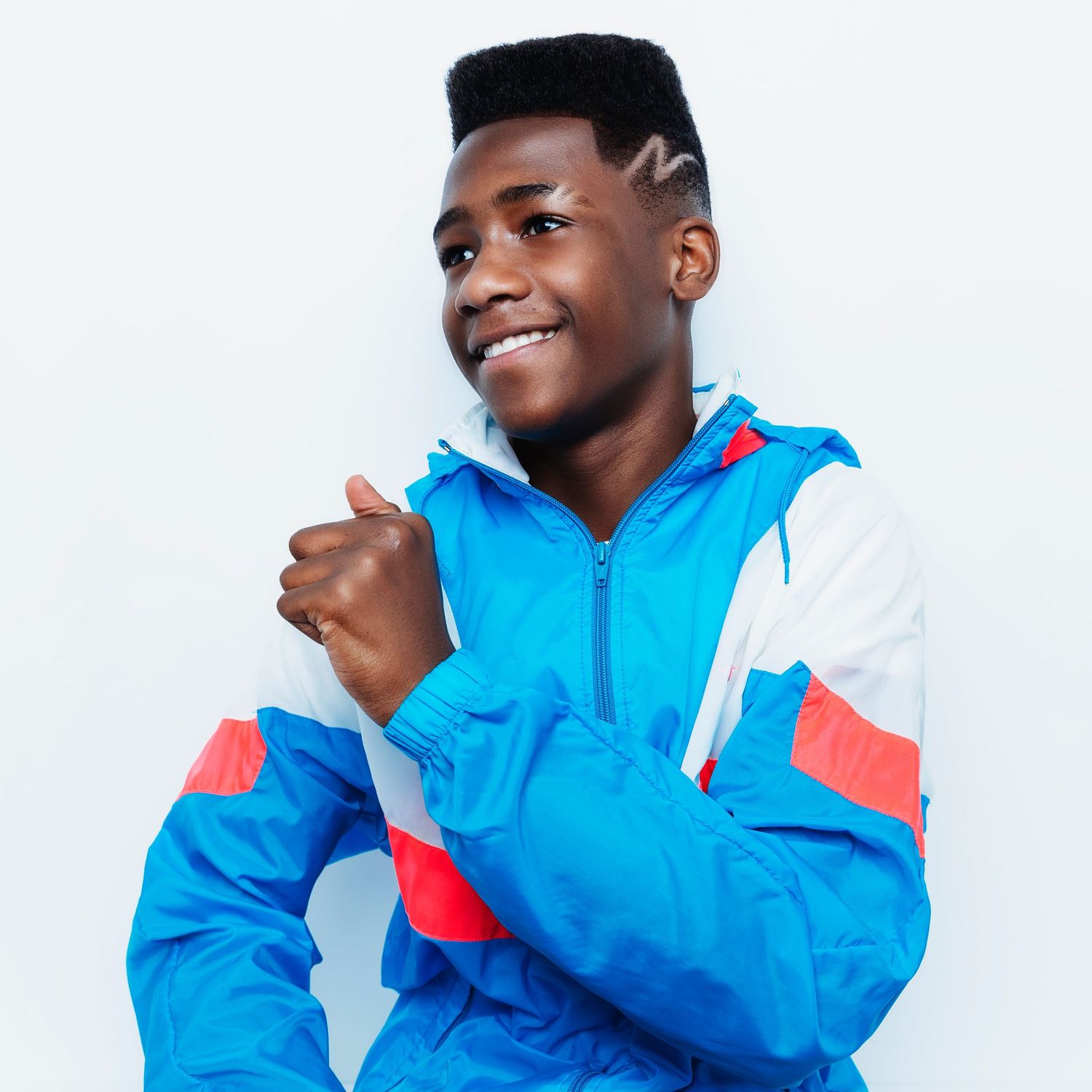 Person wearing blue and coral windbreaker jacket showing confident poses.