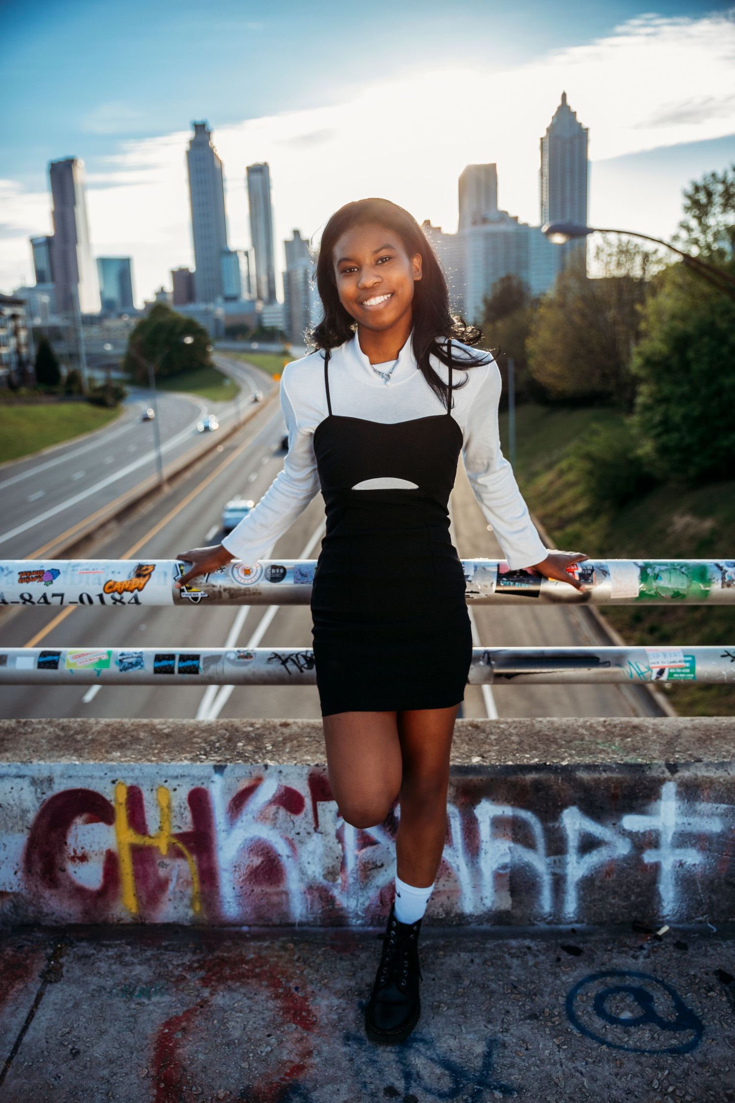 Urban photoshoot with Atlanta skyline backdrop featuring graffiti wall and street art.