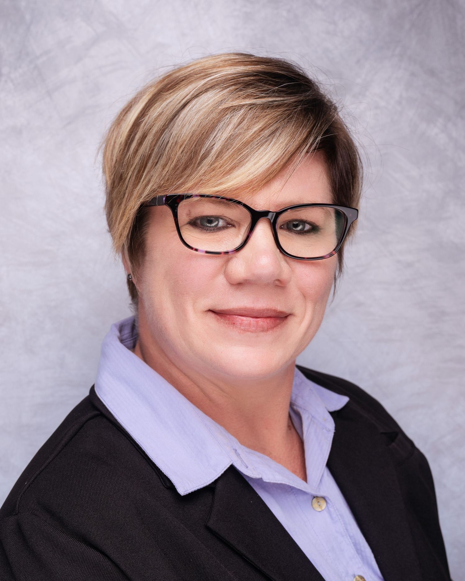 Professional portrait series showing person in black blazer and glasses with short blonde hair.