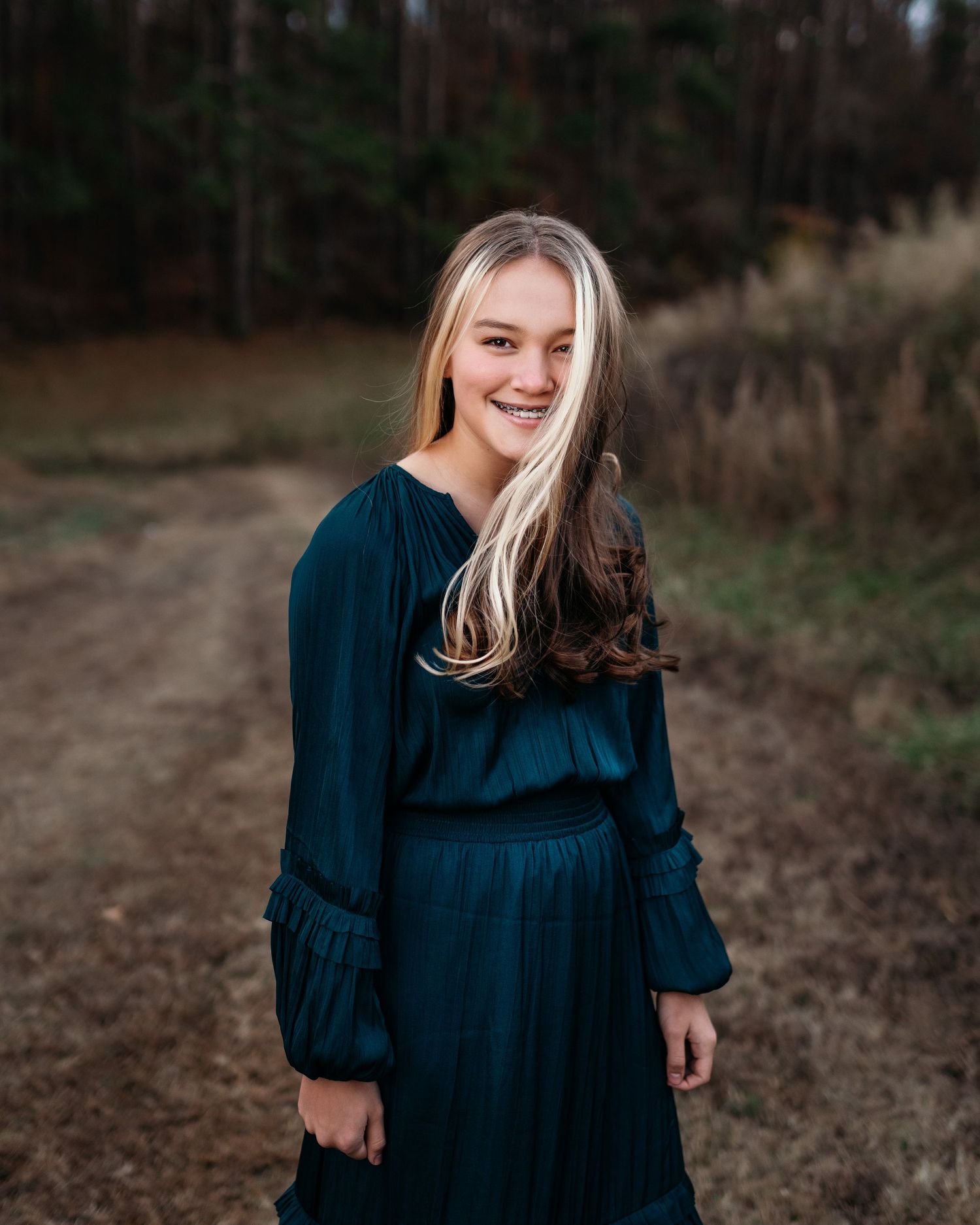 Portrait series showing person in navy blue dress against natural outdoor setting.