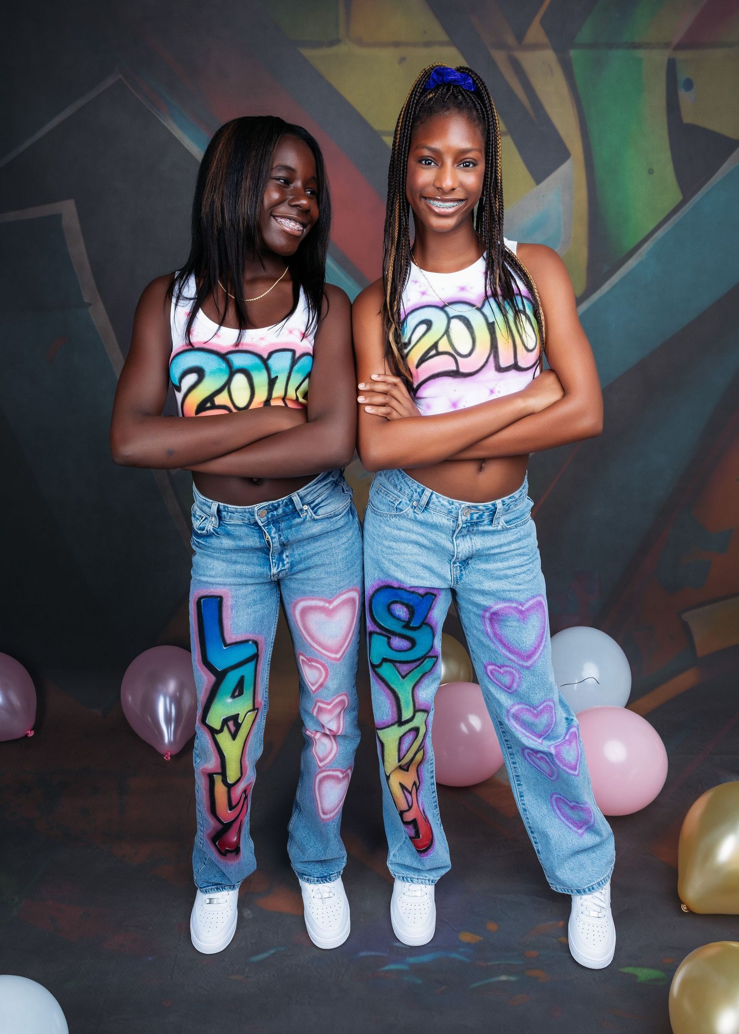 Fun portrait session against colorful graffiti wall with matching decorated denim and balloons.