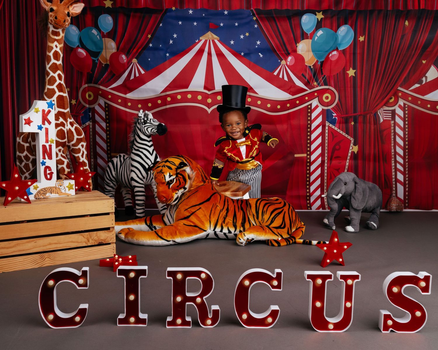 Circus-themed backdrop with red and white striped tent, candy canes, and carnival decorations.