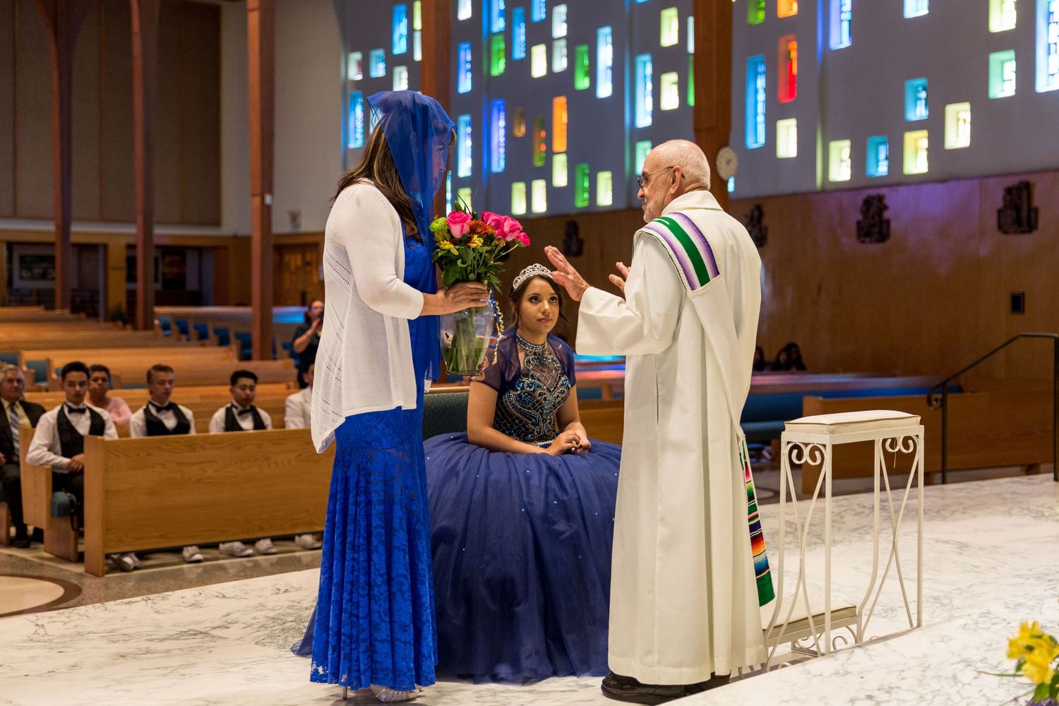 Church sanctuary with stained glass windows and wedding ceremony setup.