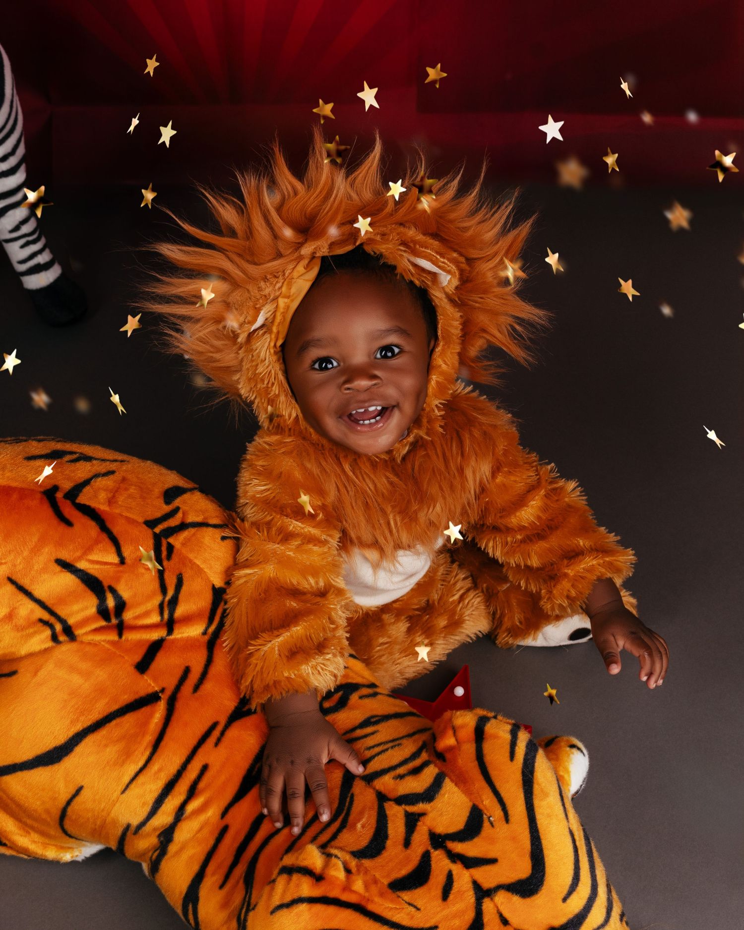 Creative portrait with orange tiger costume and sparkling star decorations against dark background.