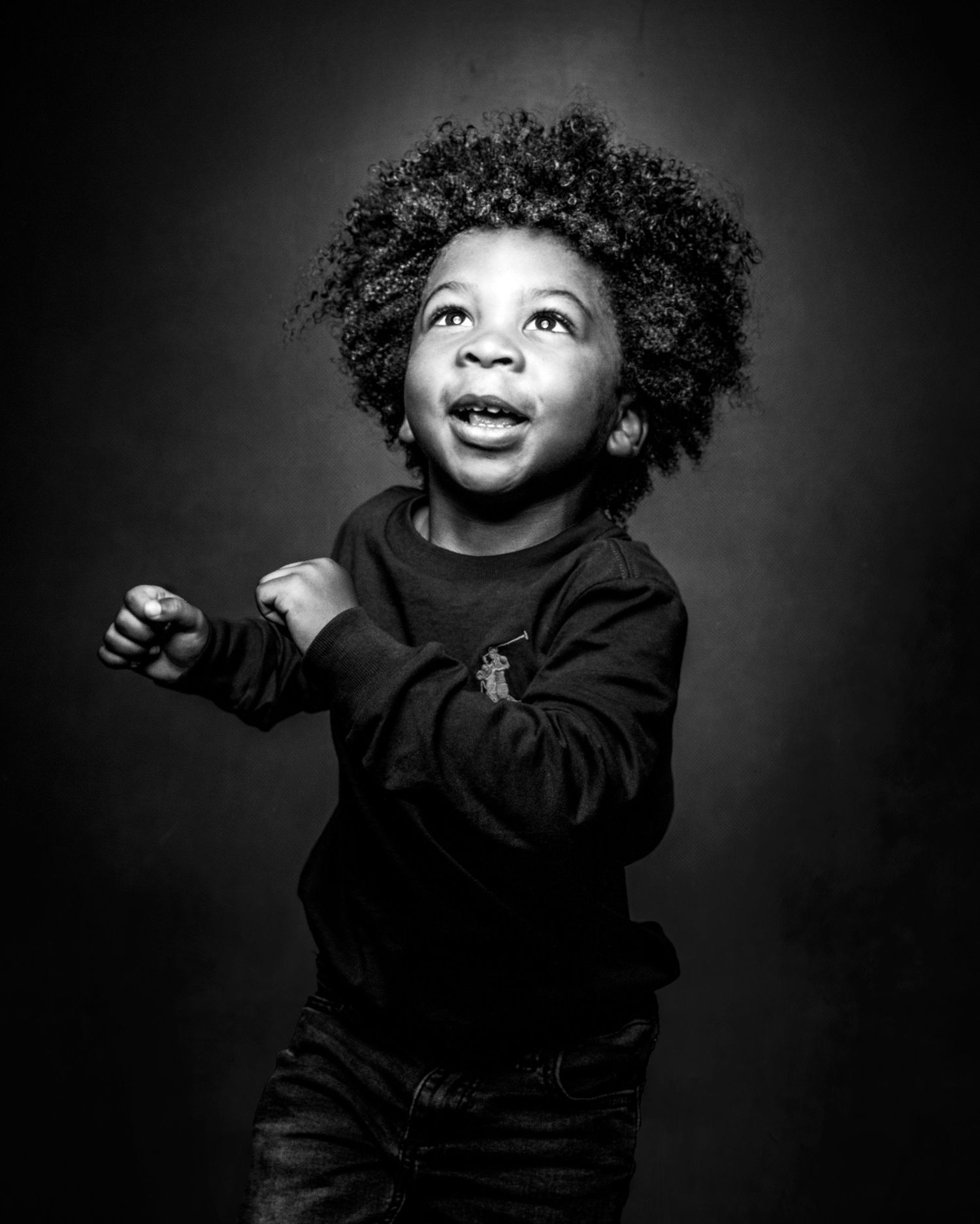 Black and white portrait series capturing joyful expressions against dark background.