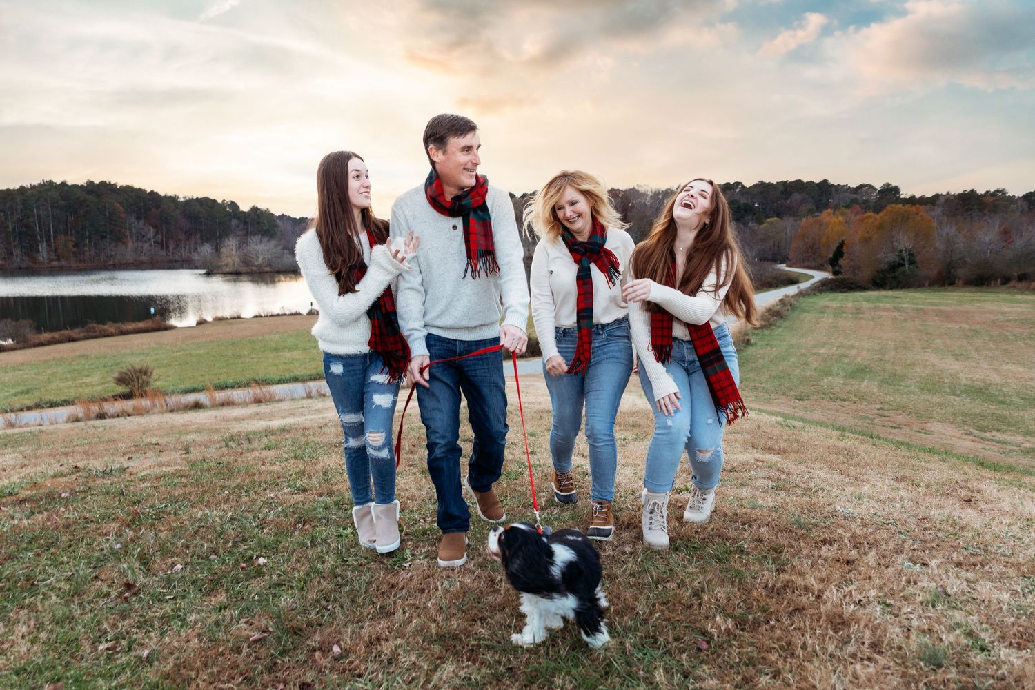 Group of friends in casual wear having fun during outdoor photoshoot at sunset.
