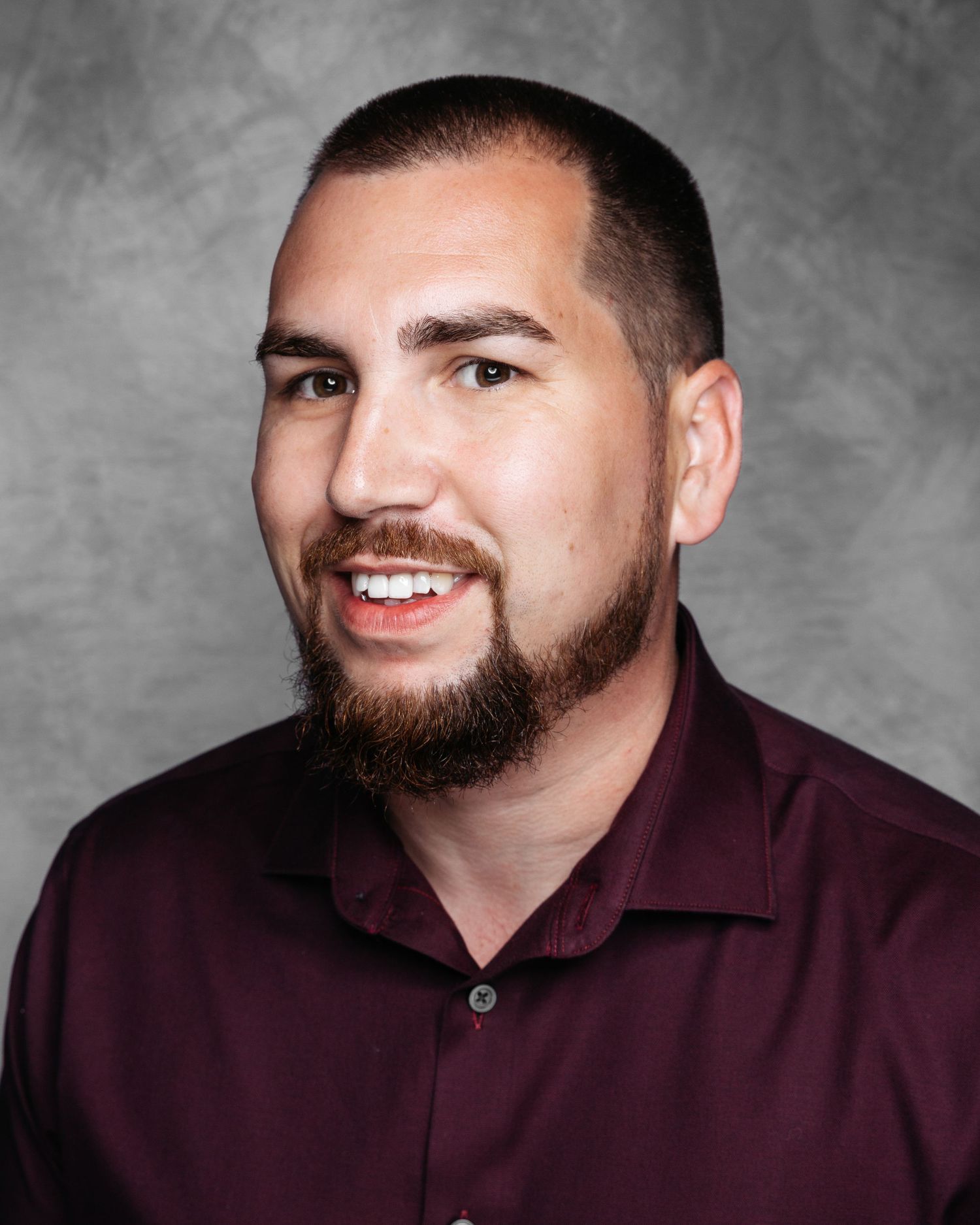 Series of professional headshots showing person in burgundy shirt against gray backdrop.