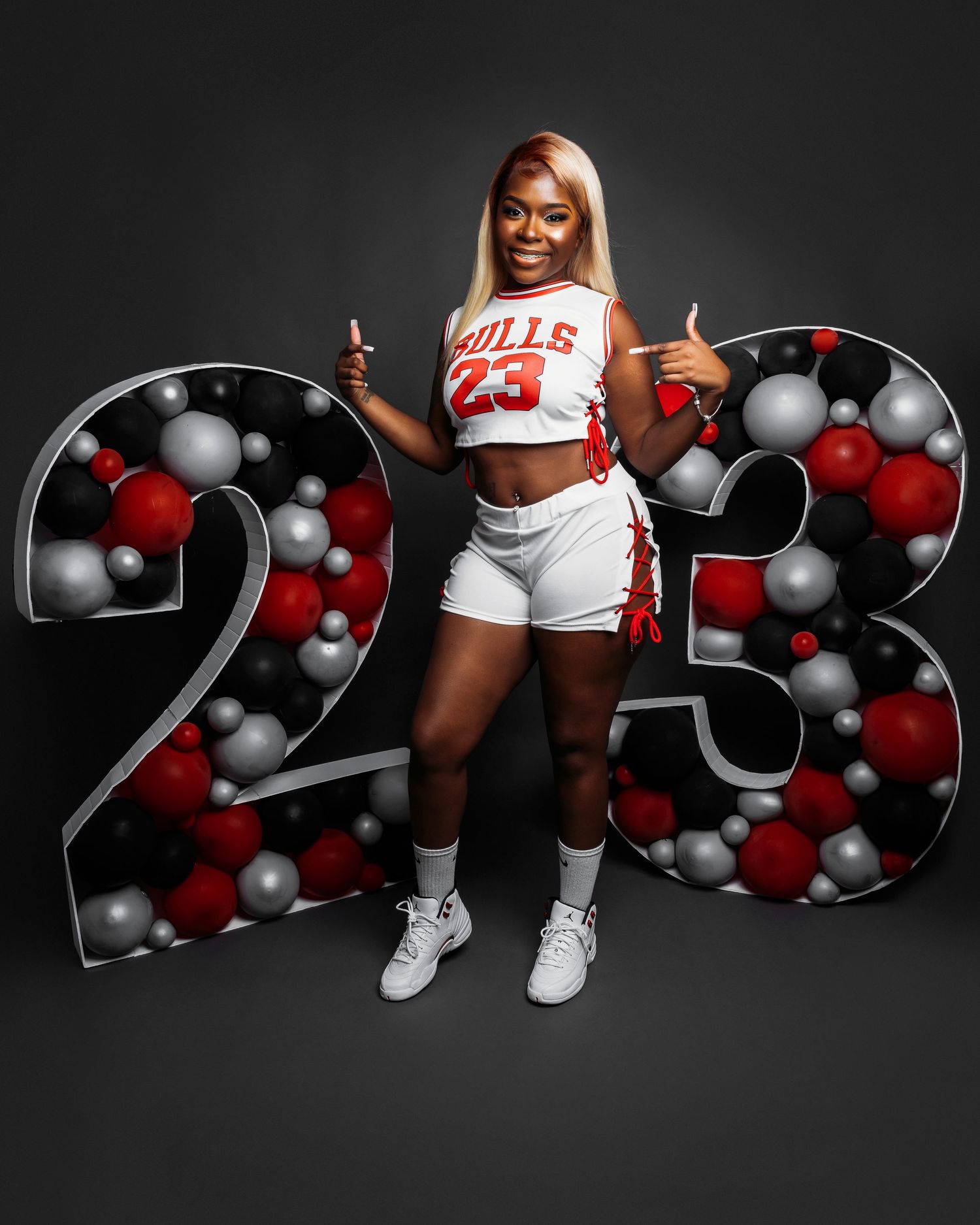 Sports-themed photo with red and silver balloon numbers against dark background.