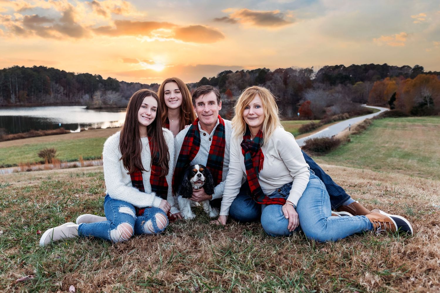 Friends lying on grass during sunset for casual outdoor photo session.
