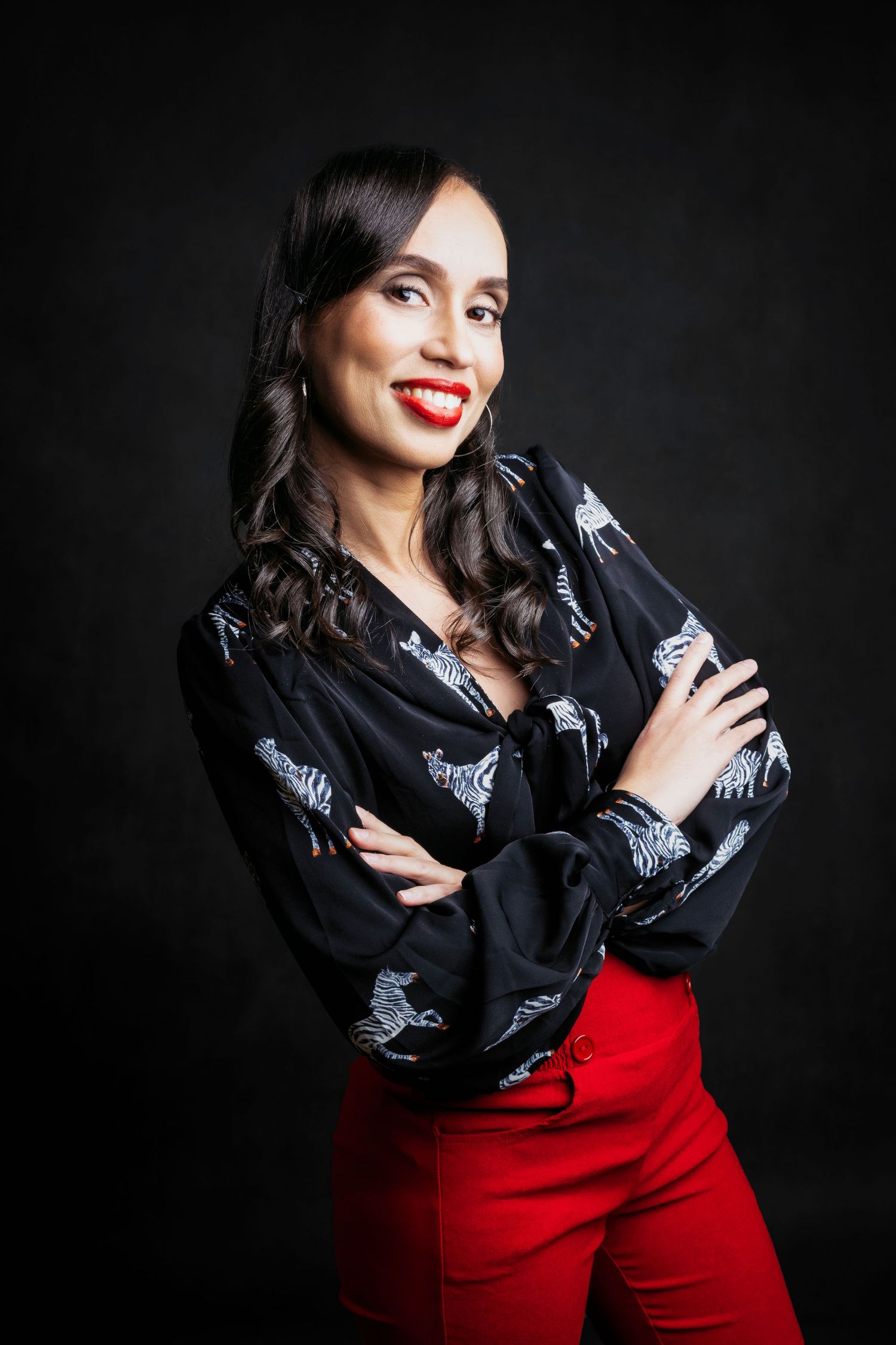 Studio portrait series in dramatic lighting featuring black blouse and red pants.