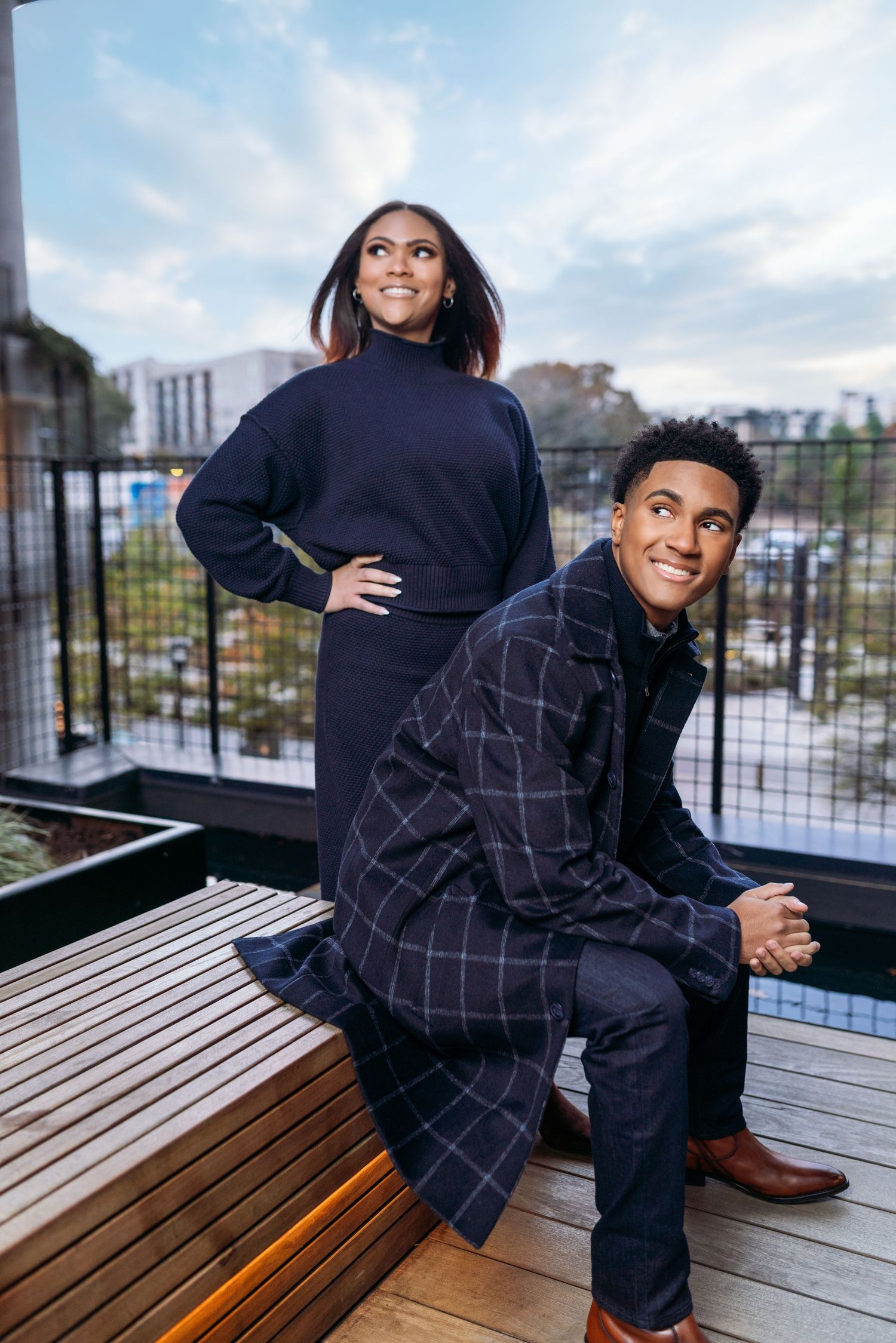 Casual family photo session on urban rooftop deck with city views.
