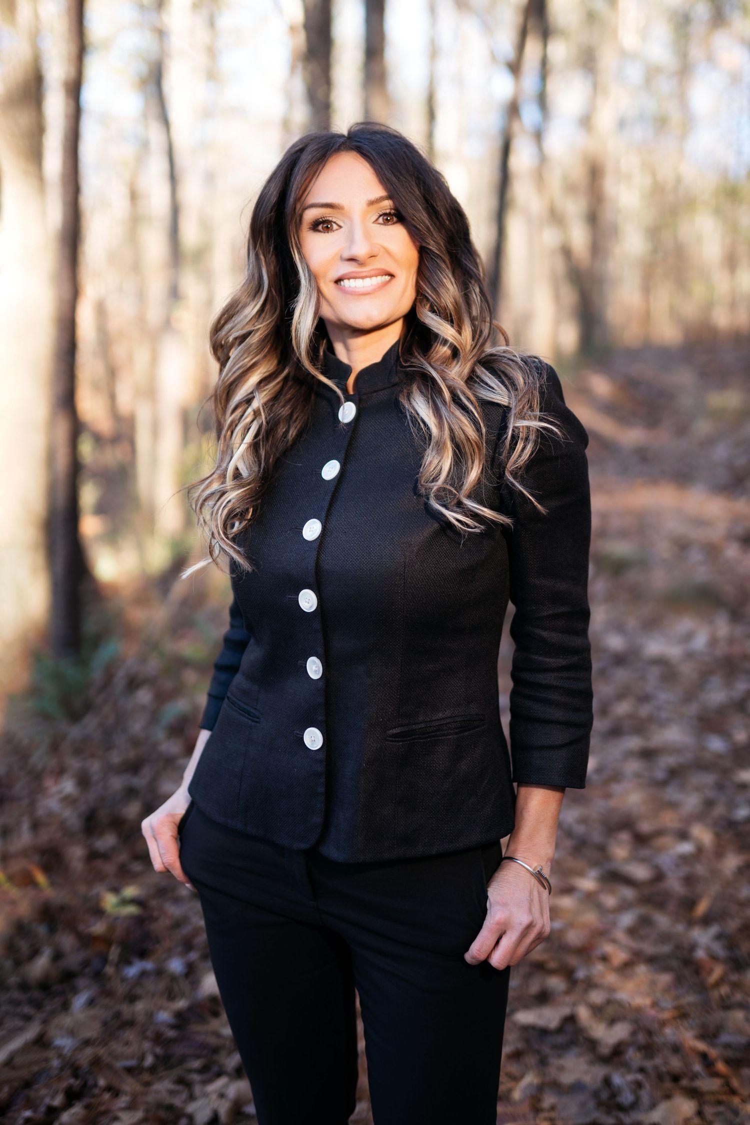 Fashion portraits of a person in a black button-up jacket against autumn forest backdrop.