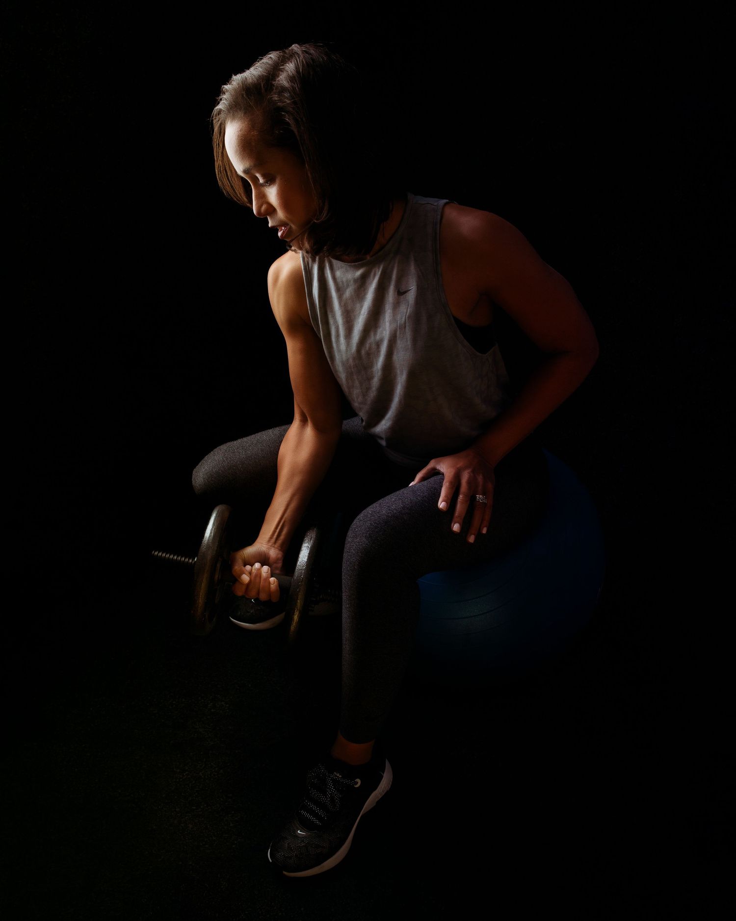 Dramatic low-key portrait showing movement in dark setting.