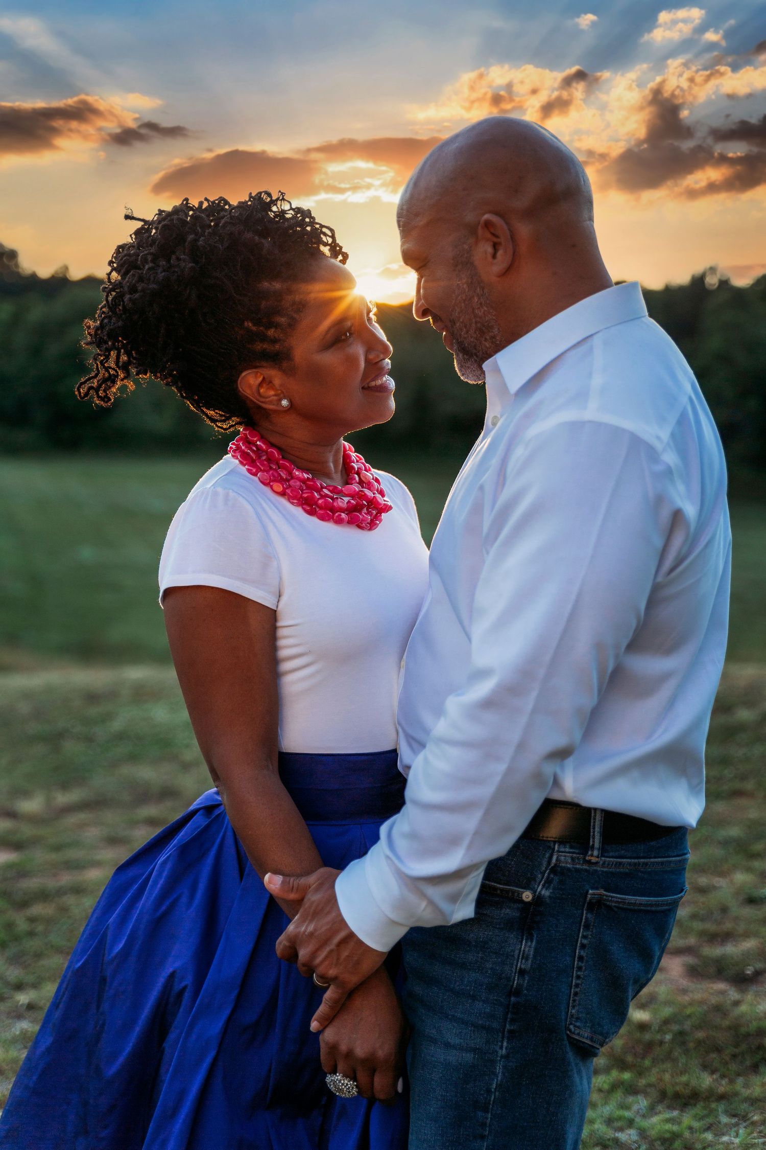 Intimate sunset portrait session in a field with warm golden lighting.