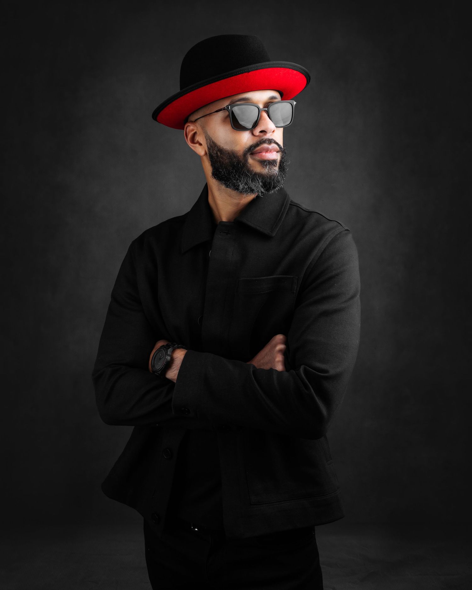 Stylish portraits featuring black outfit, red hat, and sunglasses against dark background.