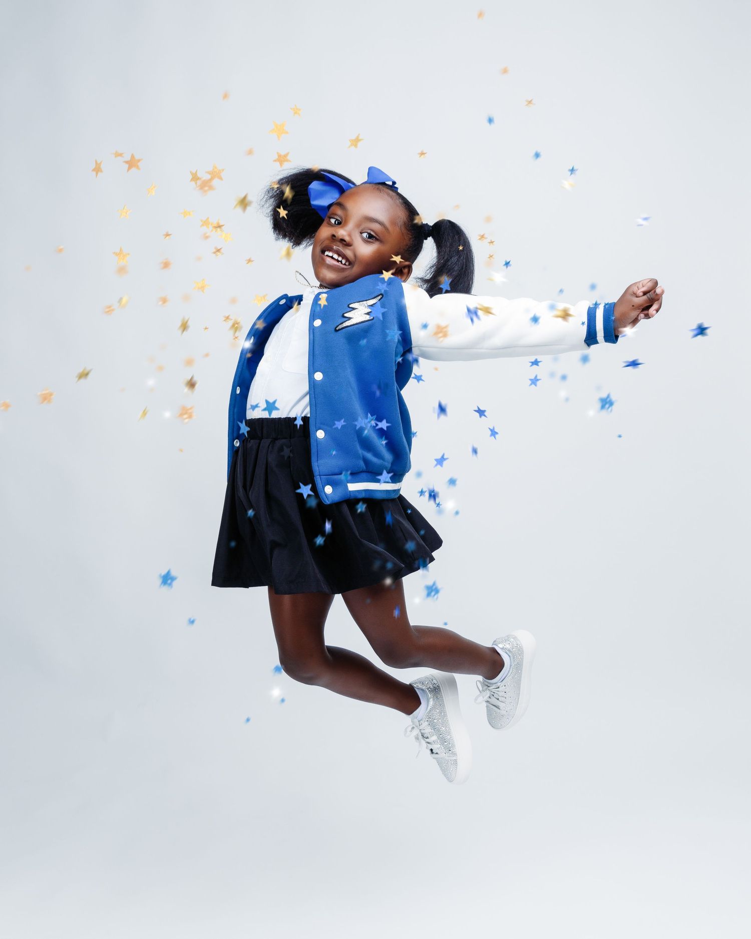 Person in blue athletic wear jumping joyfully against white background with colorful confetti.