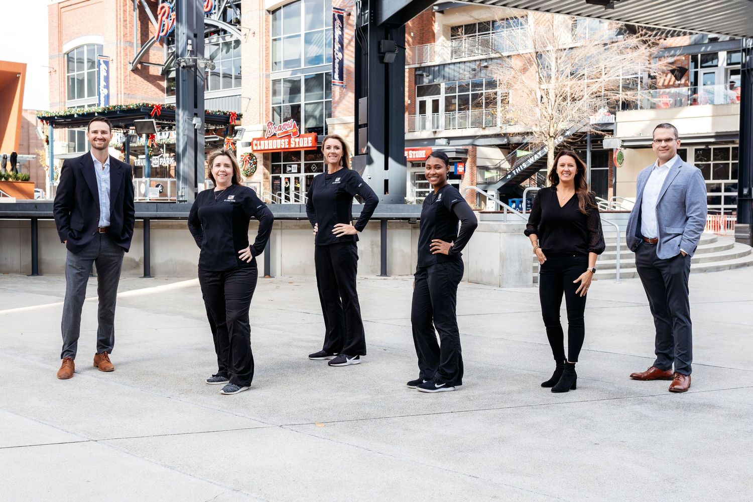 Business team members standing together outside a brick building.