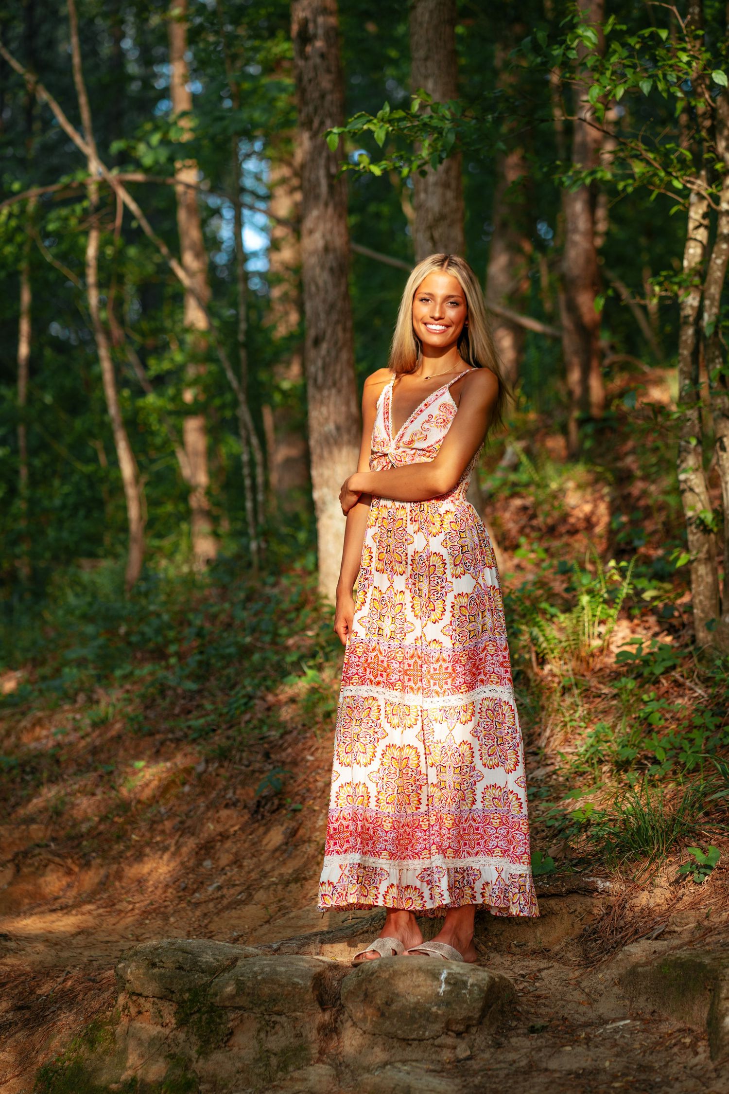 A nature-inspired portrait showcasing a patterned sundress against a wooded backdrop.