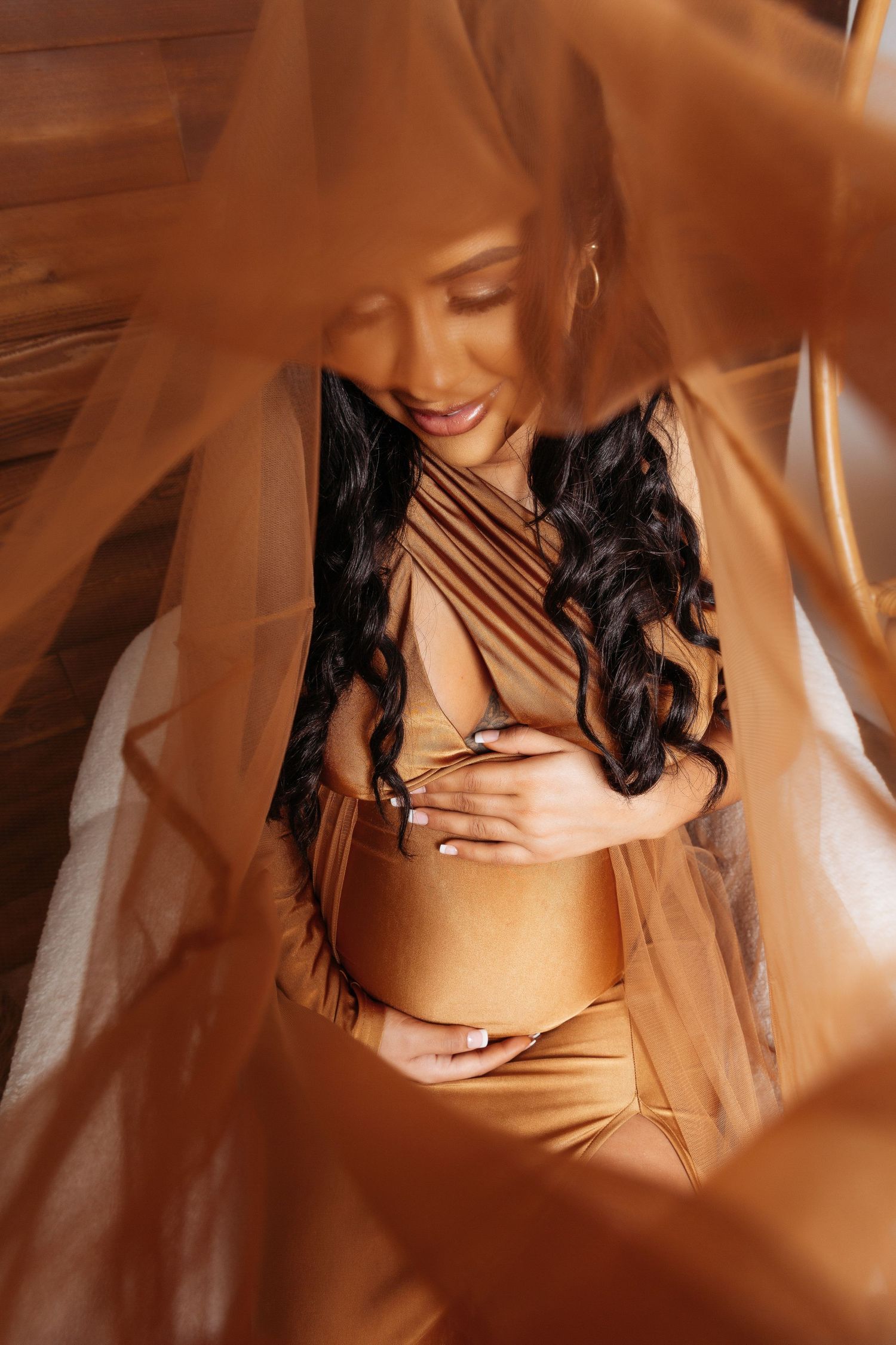 Artistic maternity photo series in warm golden tones showing close-up details of a pregnant belly.