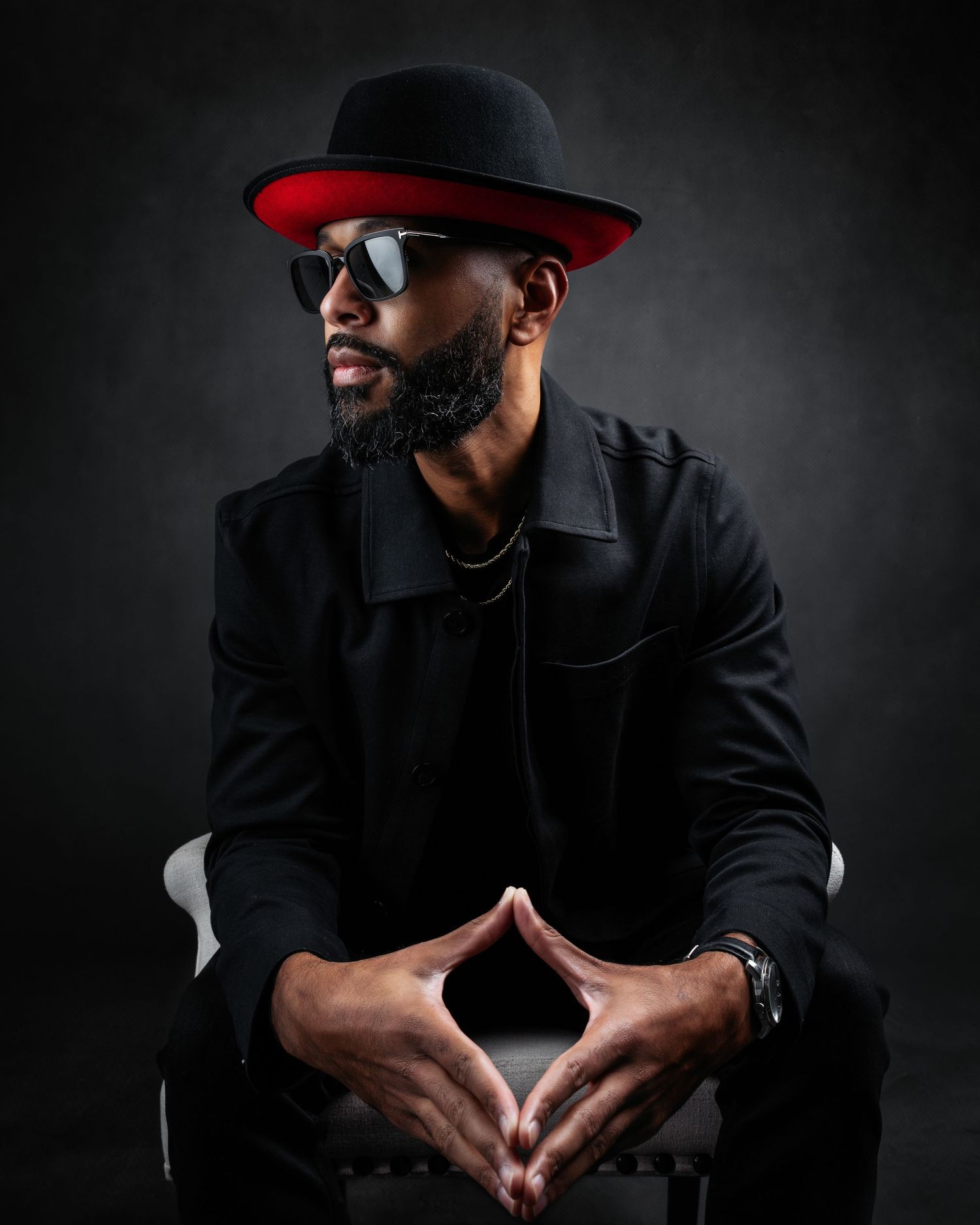 Moody studio portraits showcasing fashionable black attire and red hat in various artistic poses.