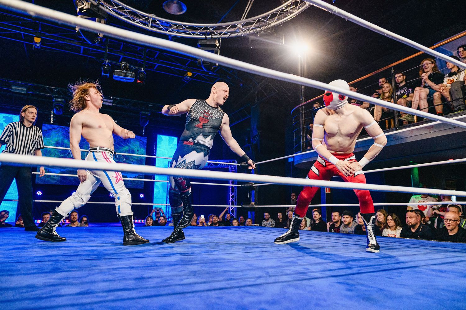 Two wrestlers battle near the ropes during an action-packed wrestling match sequence.