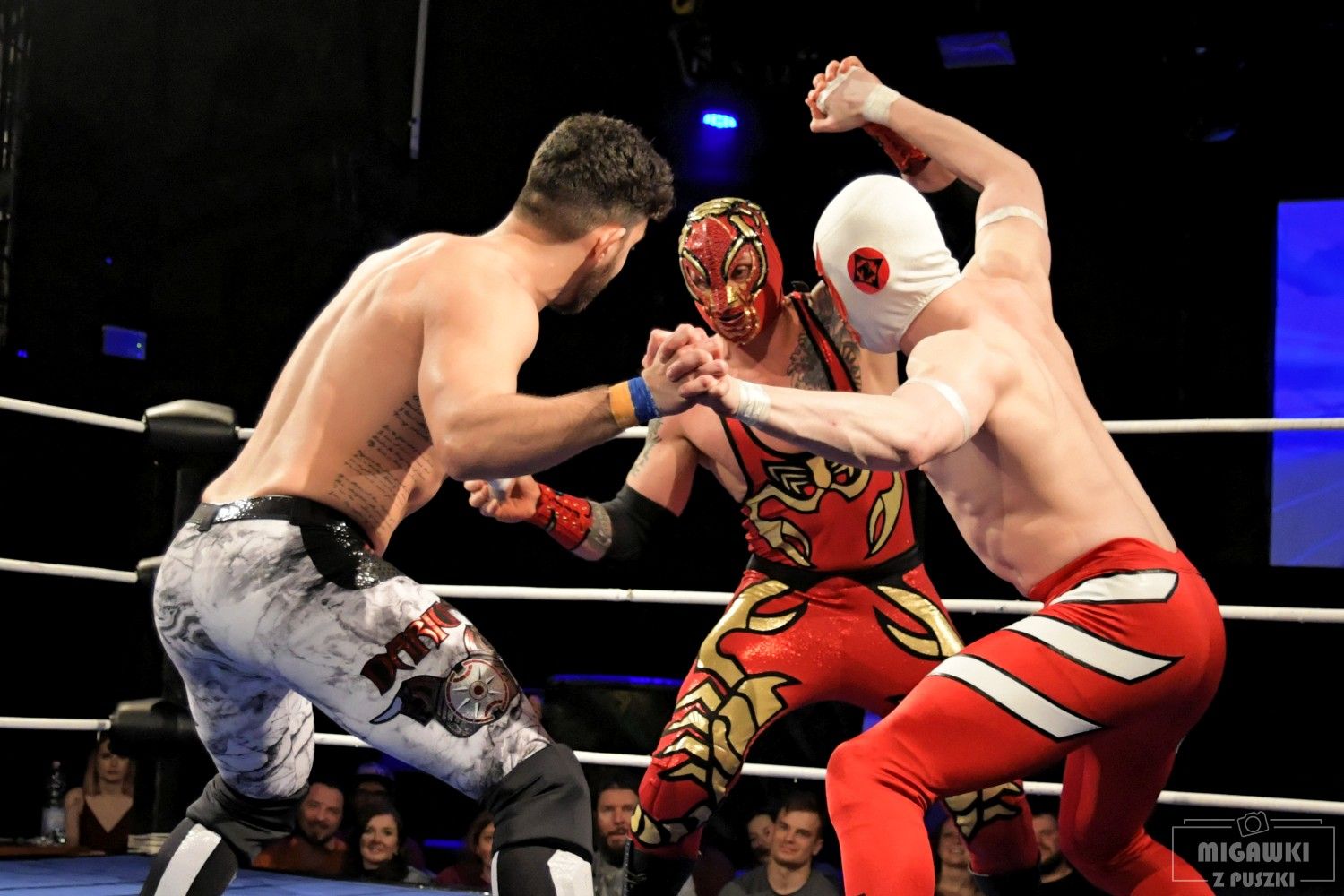 Wrestling match action sequence featuring competitors in red and white attire performing athletic moves.