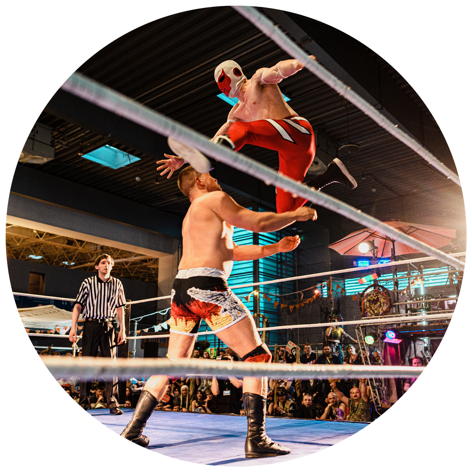 Wrestlers execute dynamic moves in a wrestling ring with dramatic lighting effects.