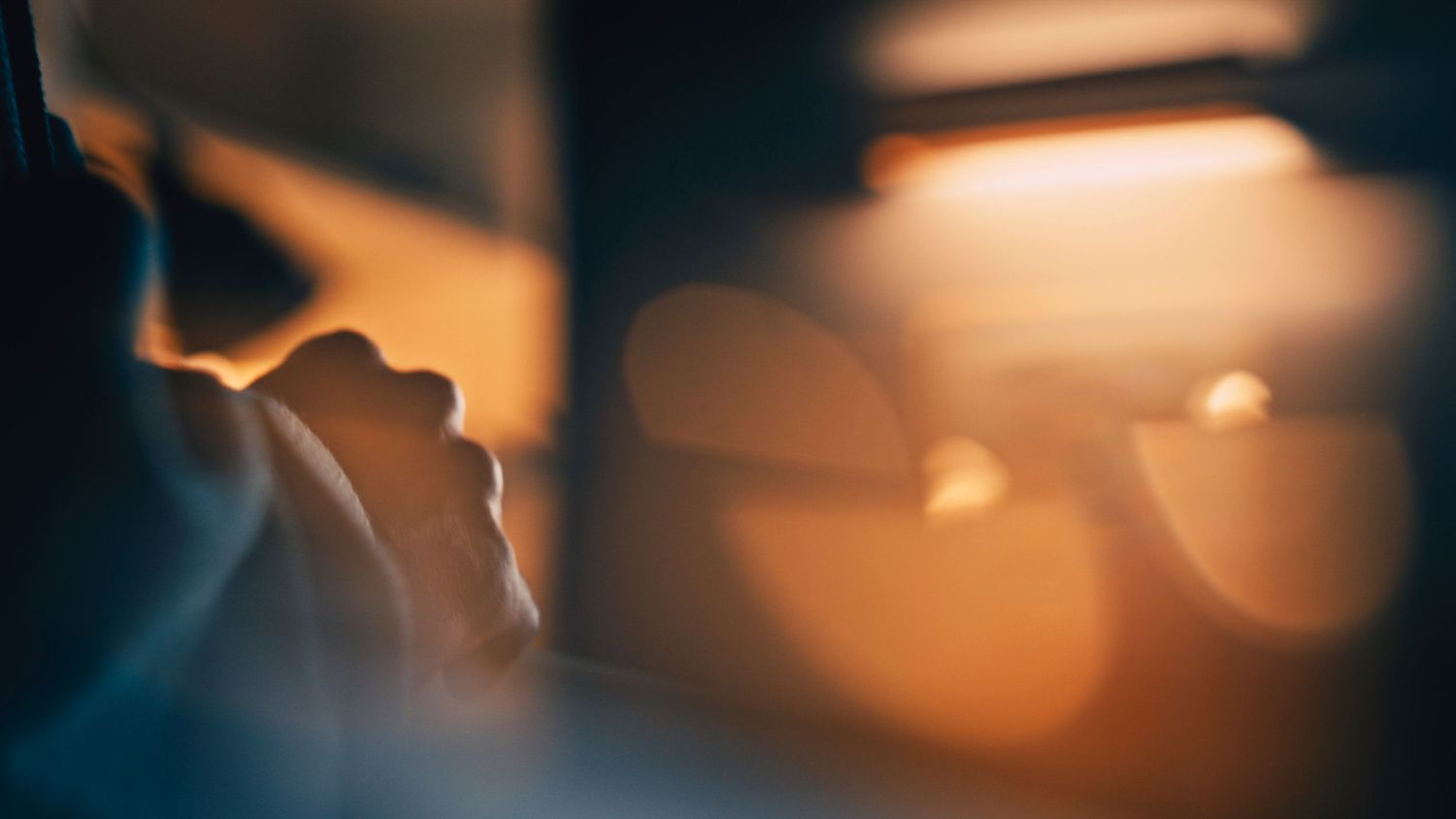 Abstract background with glowing warm lights creating a soft bokeh effect against a dark backdrop.