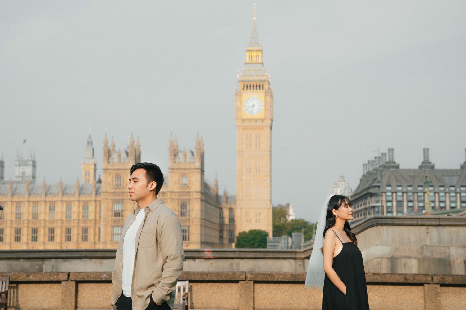 Couple poses with London's iconic Big Ben and Parliament buildings in the background.