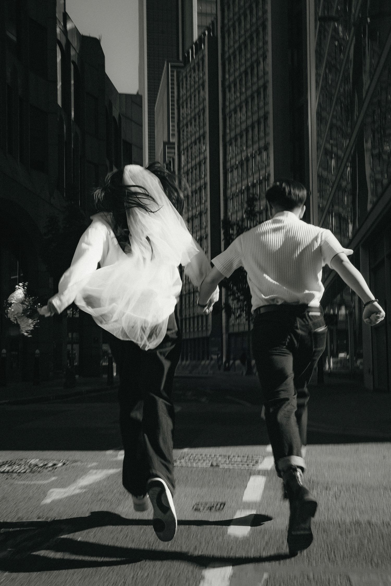 Black and white photo sequence captures dynamic dance movements against urban architecture.