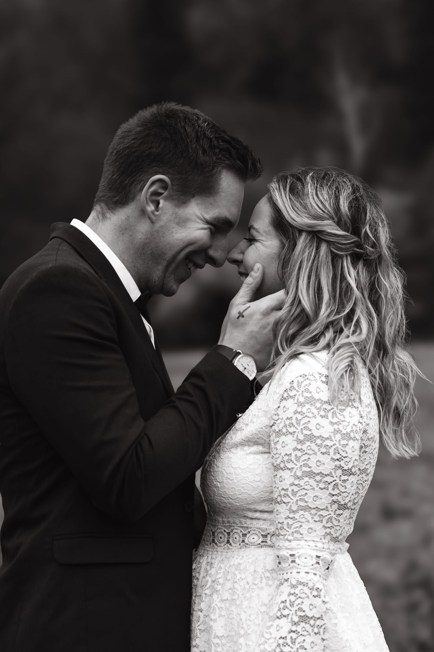 Intimate black and white portrait of newlyweds sharing a tender moment.