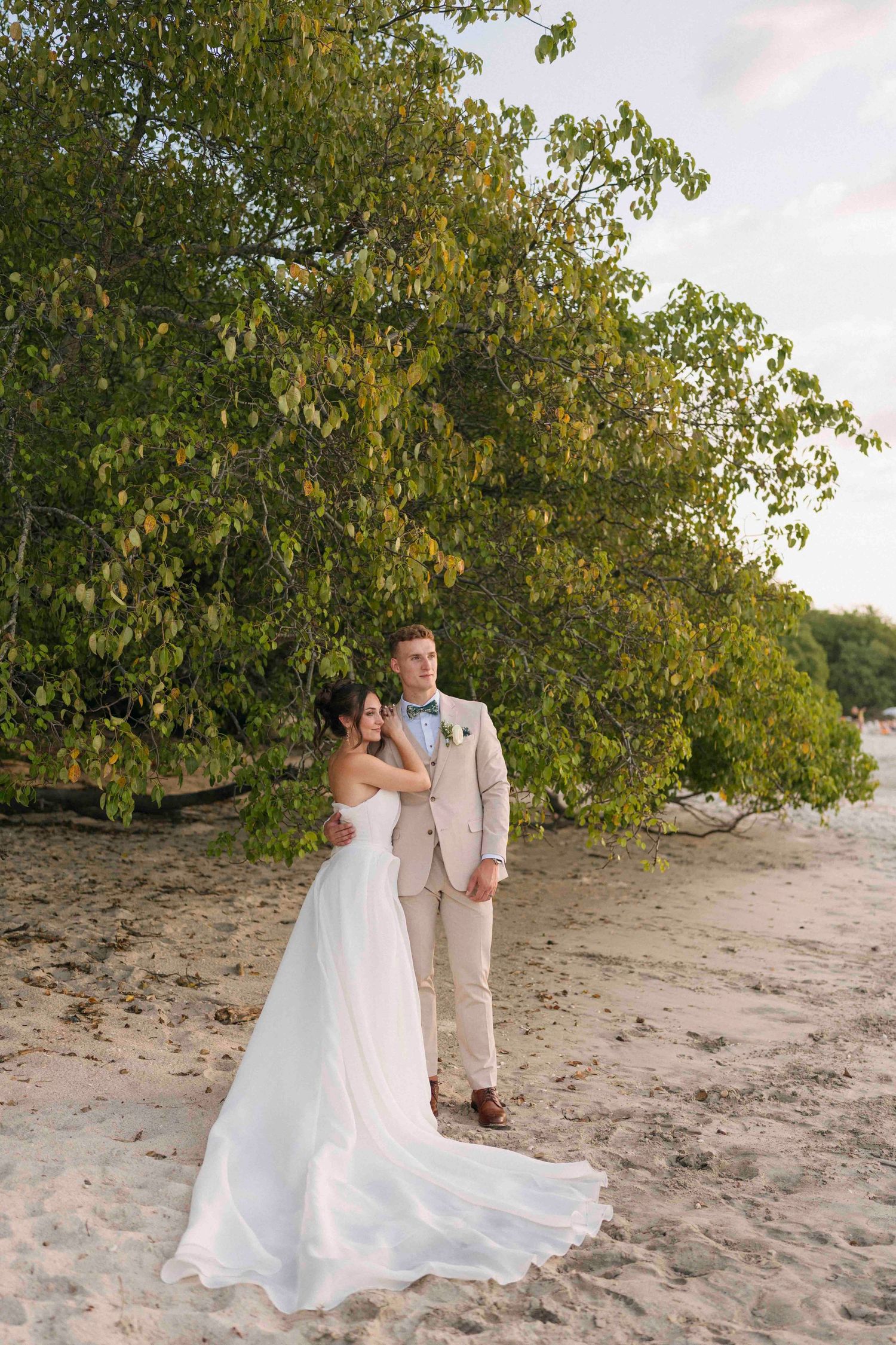 Bride and groom looking to the ocean at their wedding portraits in playa conchal