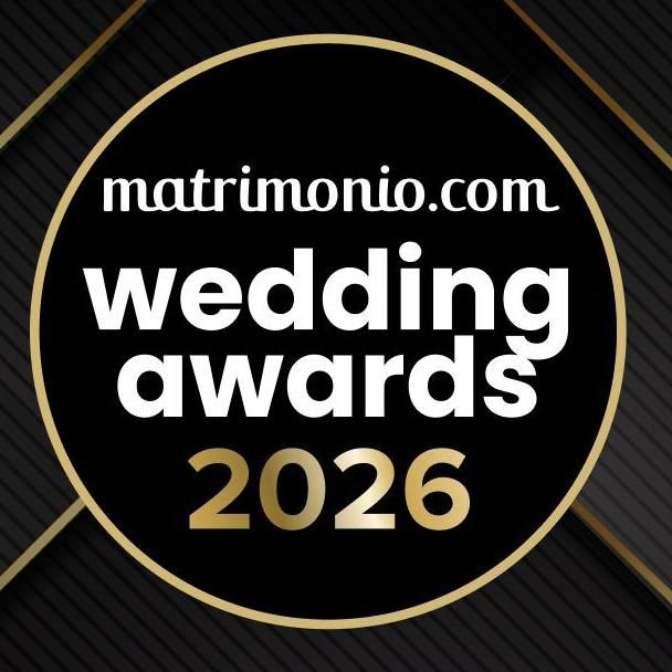 Black and gold circular logo for Matrimonio.com Wedding Awards 2026 on a dark geometric background.