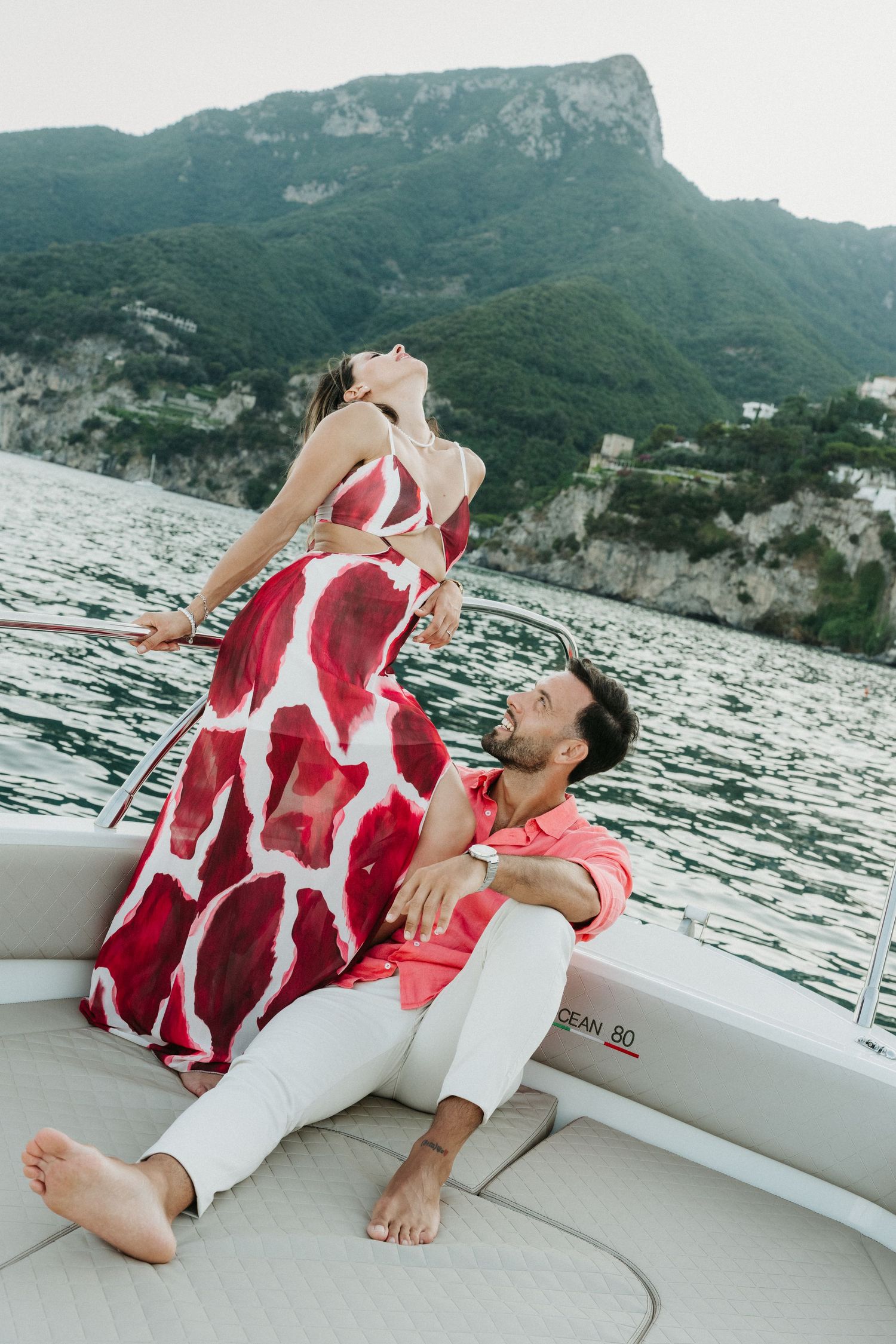 Couple enjoying a romantic moment on a boat with scenic mountain views at Lake Garda, Italy.