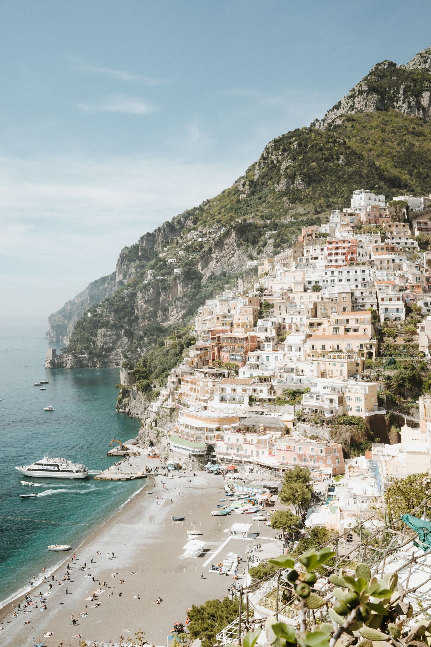 Scenic aerial view of Positano's colorful buildings cascading down cliffs along the Amalfi Coast's turquoise waters.
