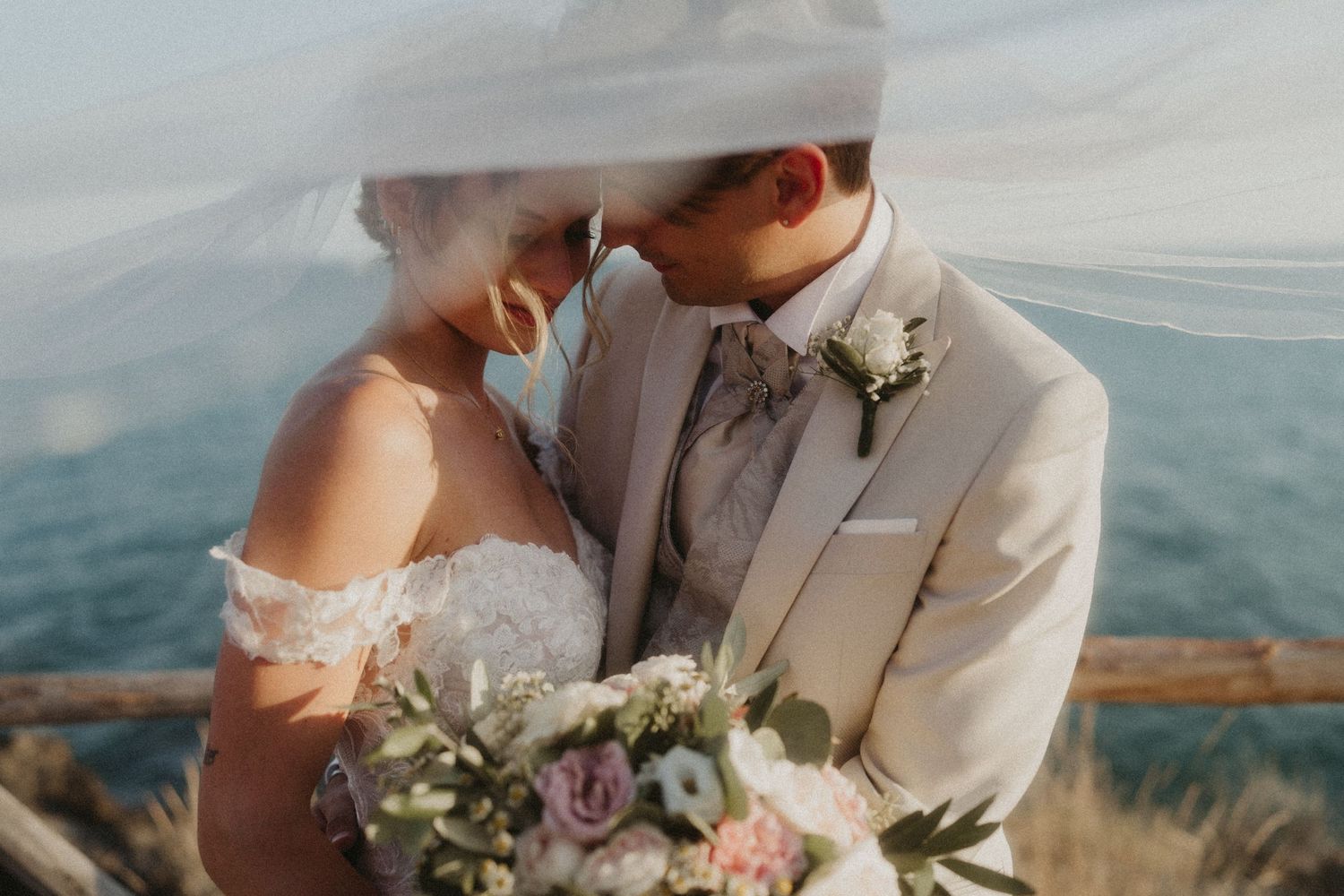 Couple embracing during golden hour with mountain views in the background.