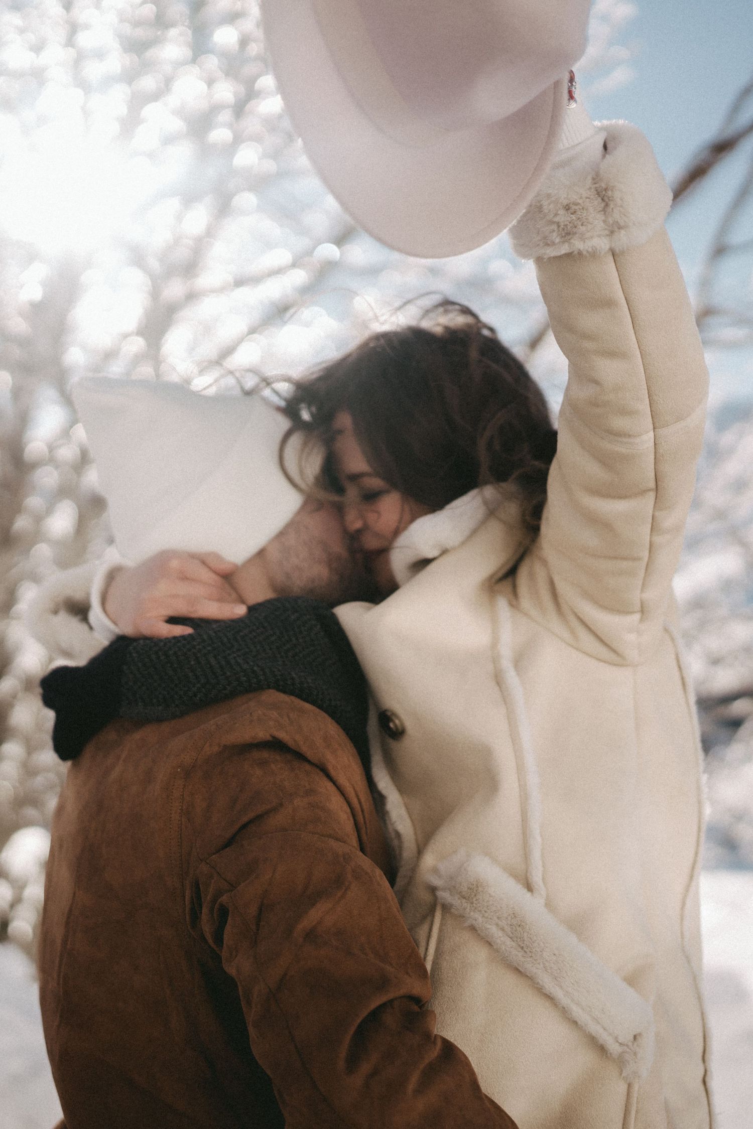 Couple embracing in winter scene with white snow and natural lighting.