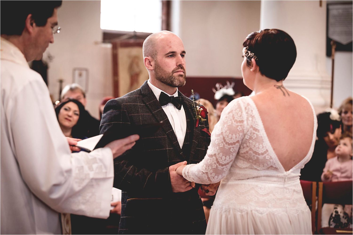 The wedding reception is filled with joyful guests dancing and celebrating together on the dance floor.