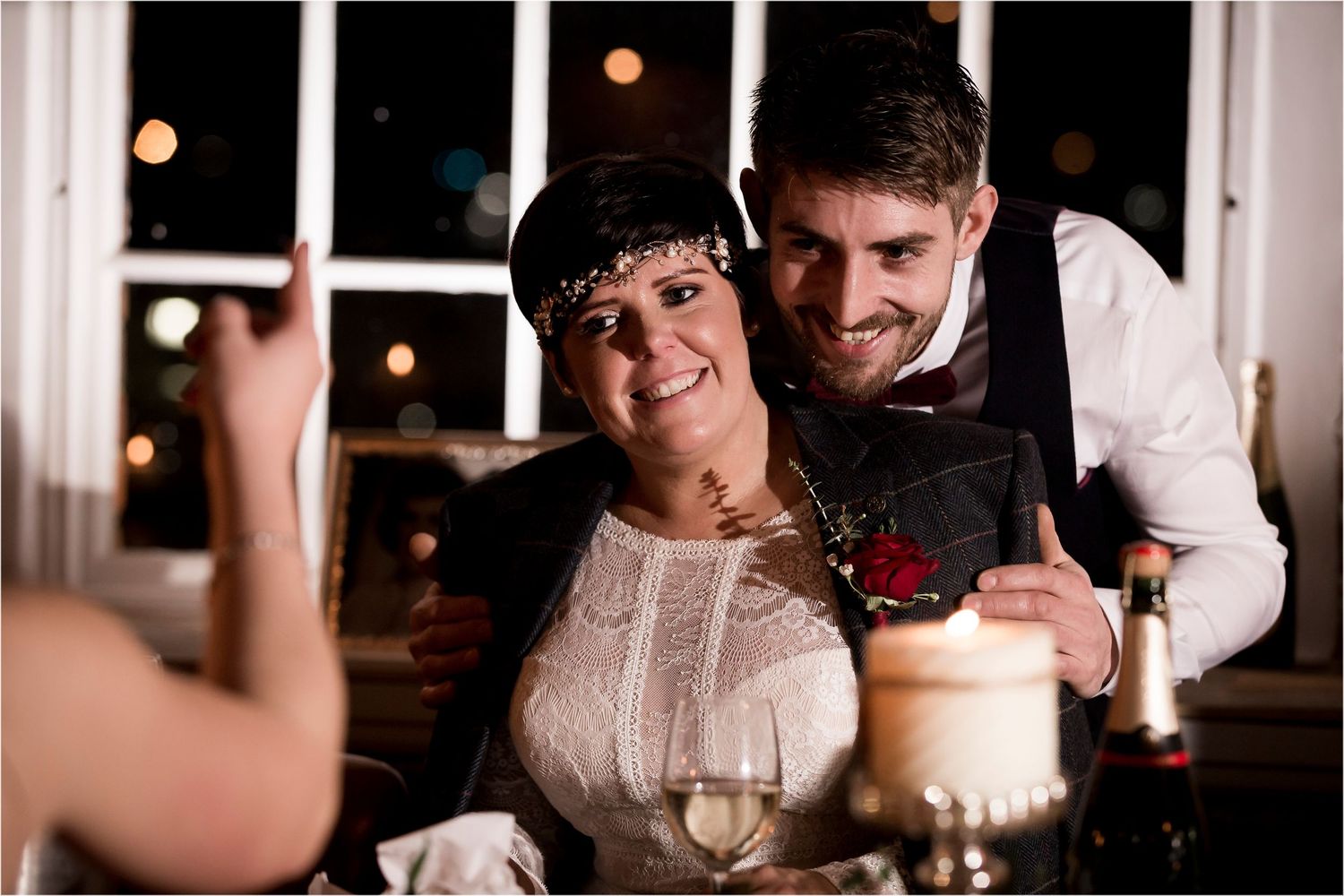 Romantic dinner scene with candlelight and wine glasses on a table during an evening celebration.