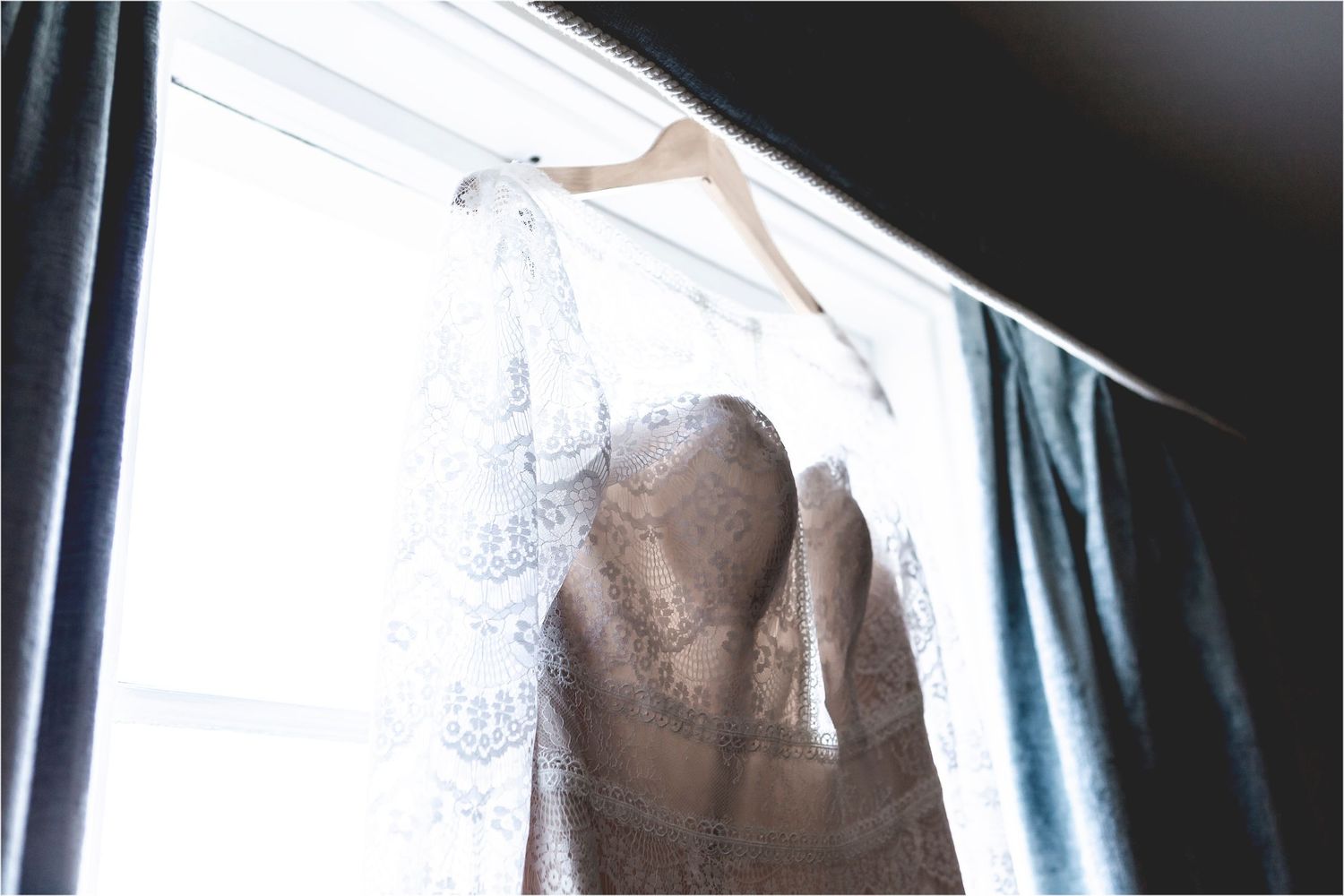 A dimly lit figure is shown through a white shower curtain with water droplets running down their back.