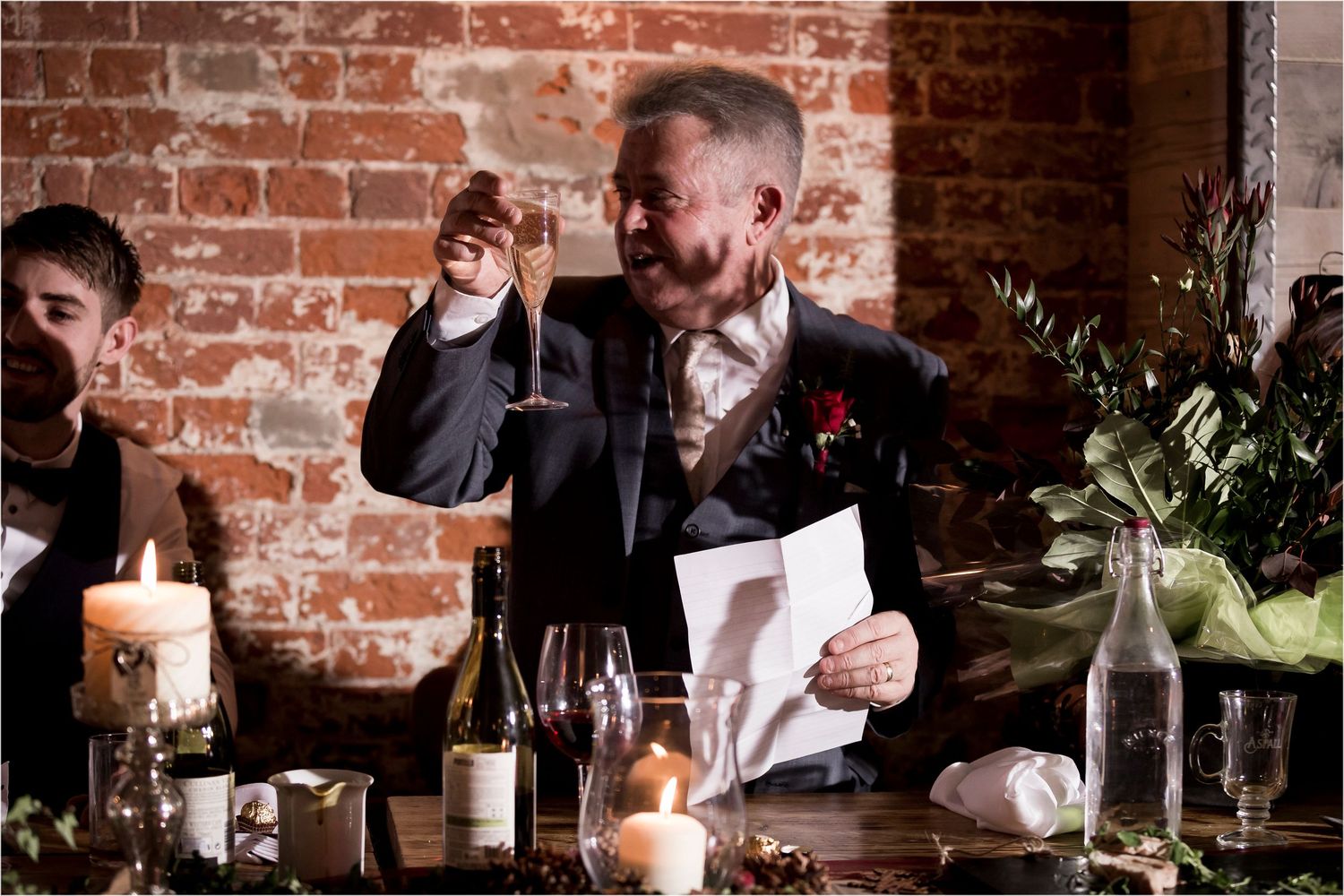 Friends gather at a rustic bar with exposed brick walls, enjoying drinks and conversation in warm lighting.