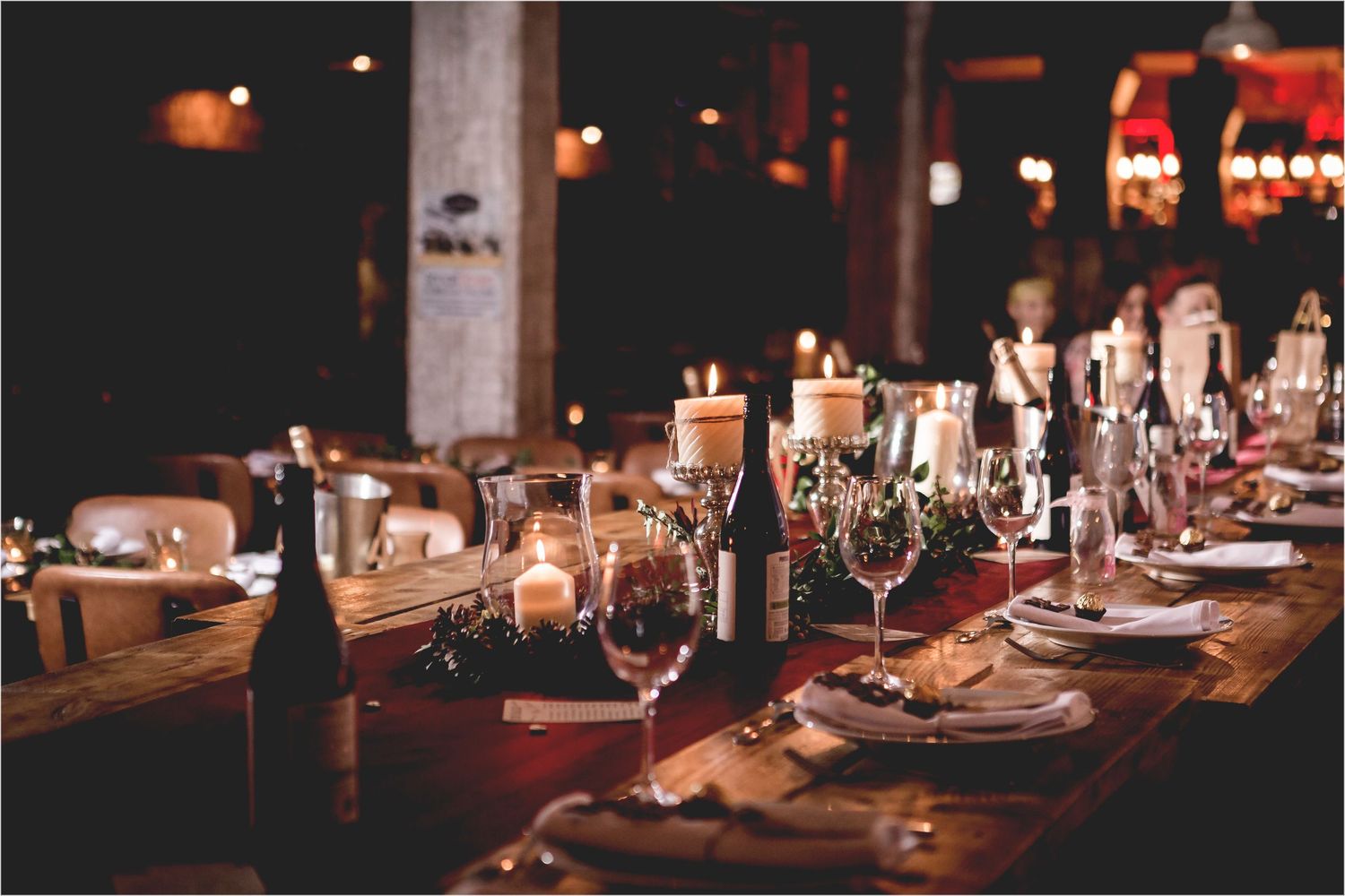 An elegant table setting with wine glasses and candlelight at a rustic restaurant dinner event.