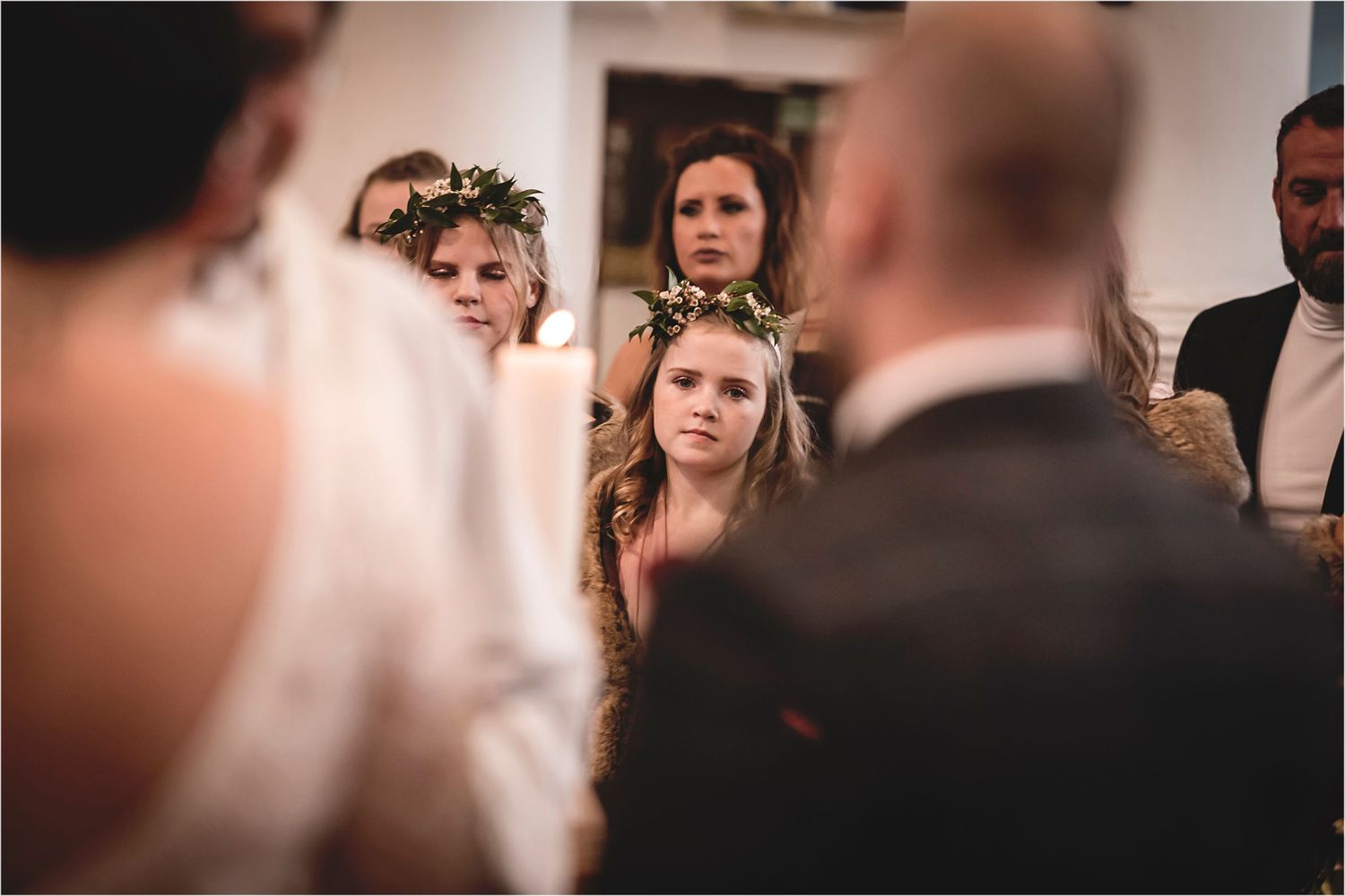 A serene wedding ceremony scene with soft lighting and blurred figures creating an intimate atmosphere.