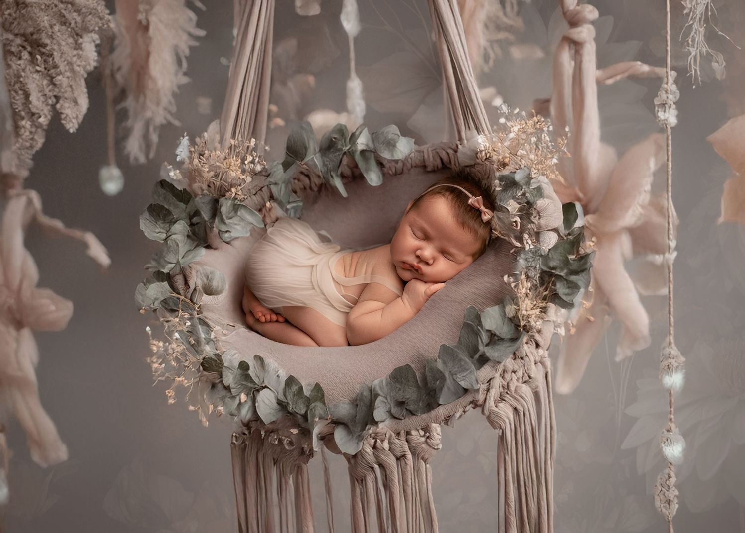 A sleeping newborn baby lies peacefully in a rustic wooden swing decorated with delicate floral arrangements.