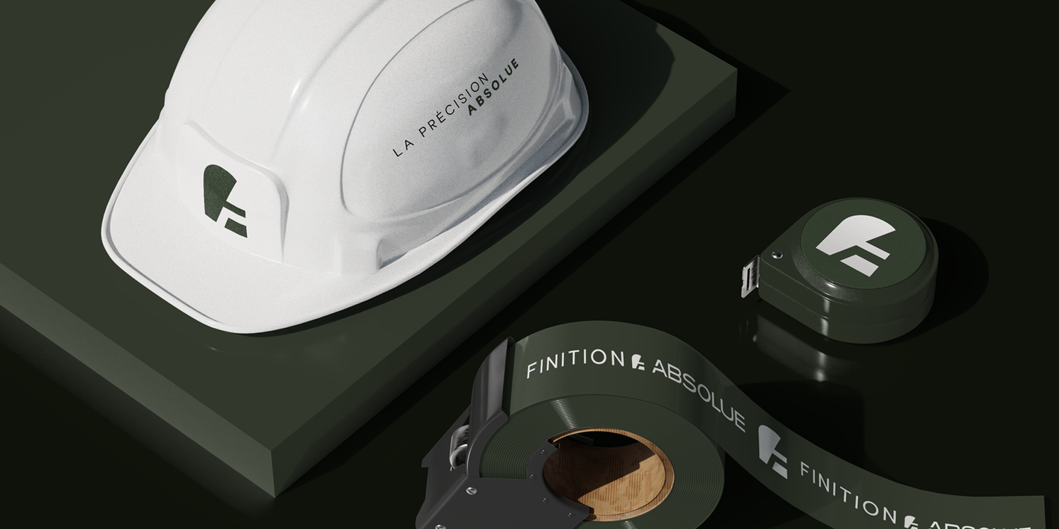 A white construction hard hat and dark branded materials displayed on a black surface in moody lighting.