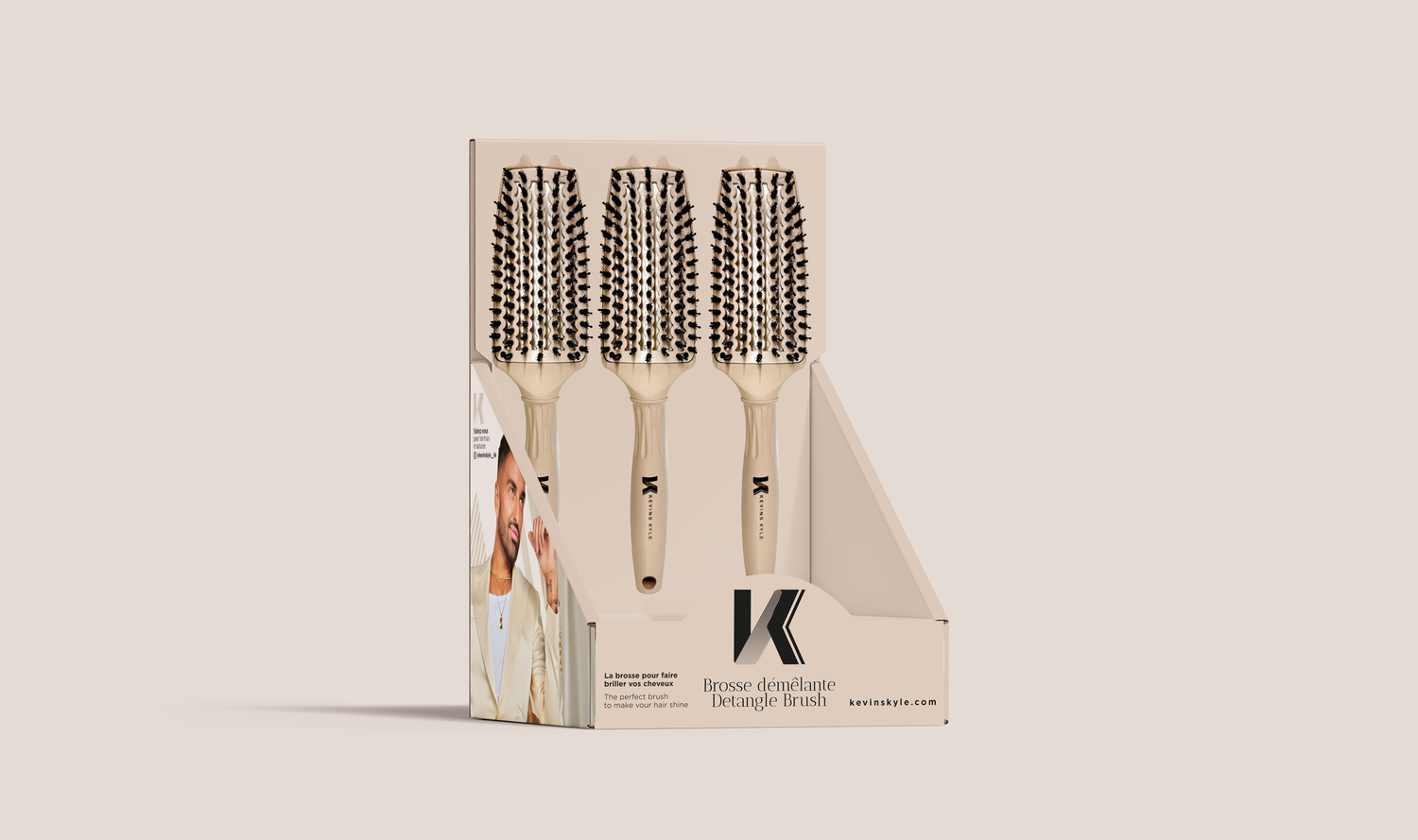 Display box of four beige-handled boar bristle hair brushes arranged in a retail packaging stand with brand logo.